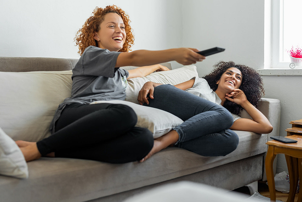 Cozy living room setting with two people relaxing on a comfortable sofa, enhancing a warm and inviting home atmosphere.