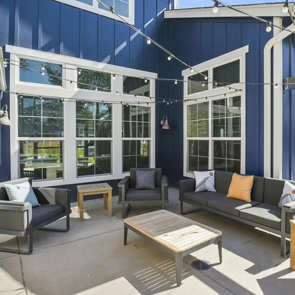 Charming outdoor patio with stylish seating, string lights, and modern architectural design.