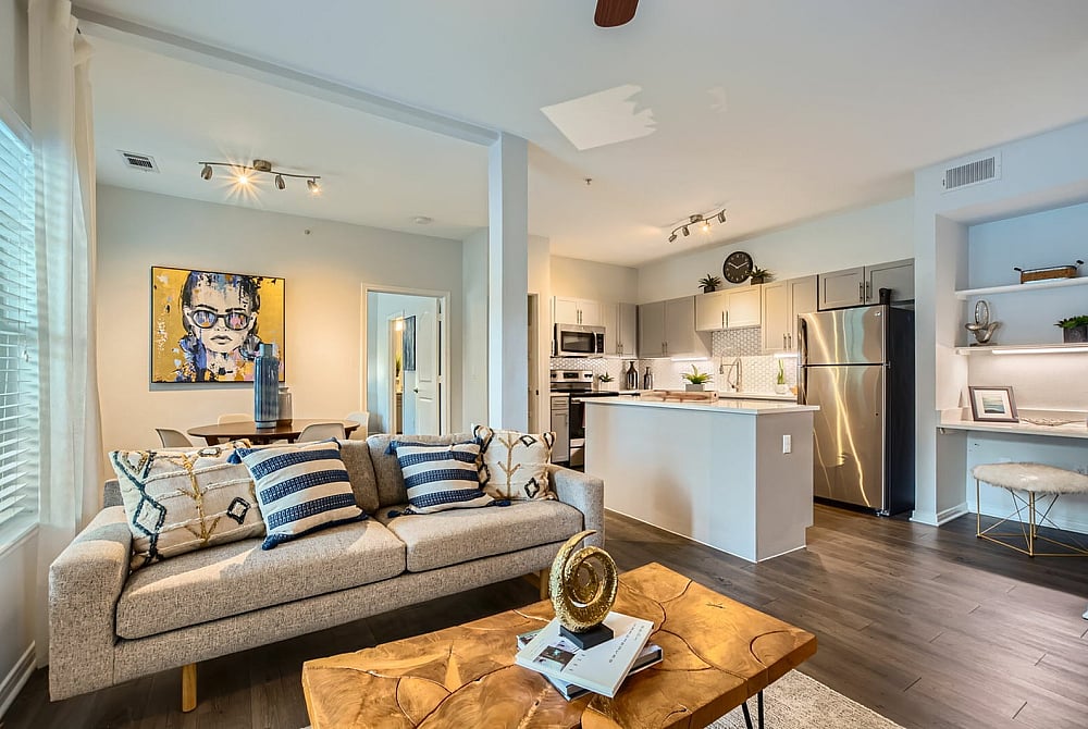 Chic apartment interior showcasing a modern open-concept living room, stylish kitchen, and cozy dining area with contemporary decor.