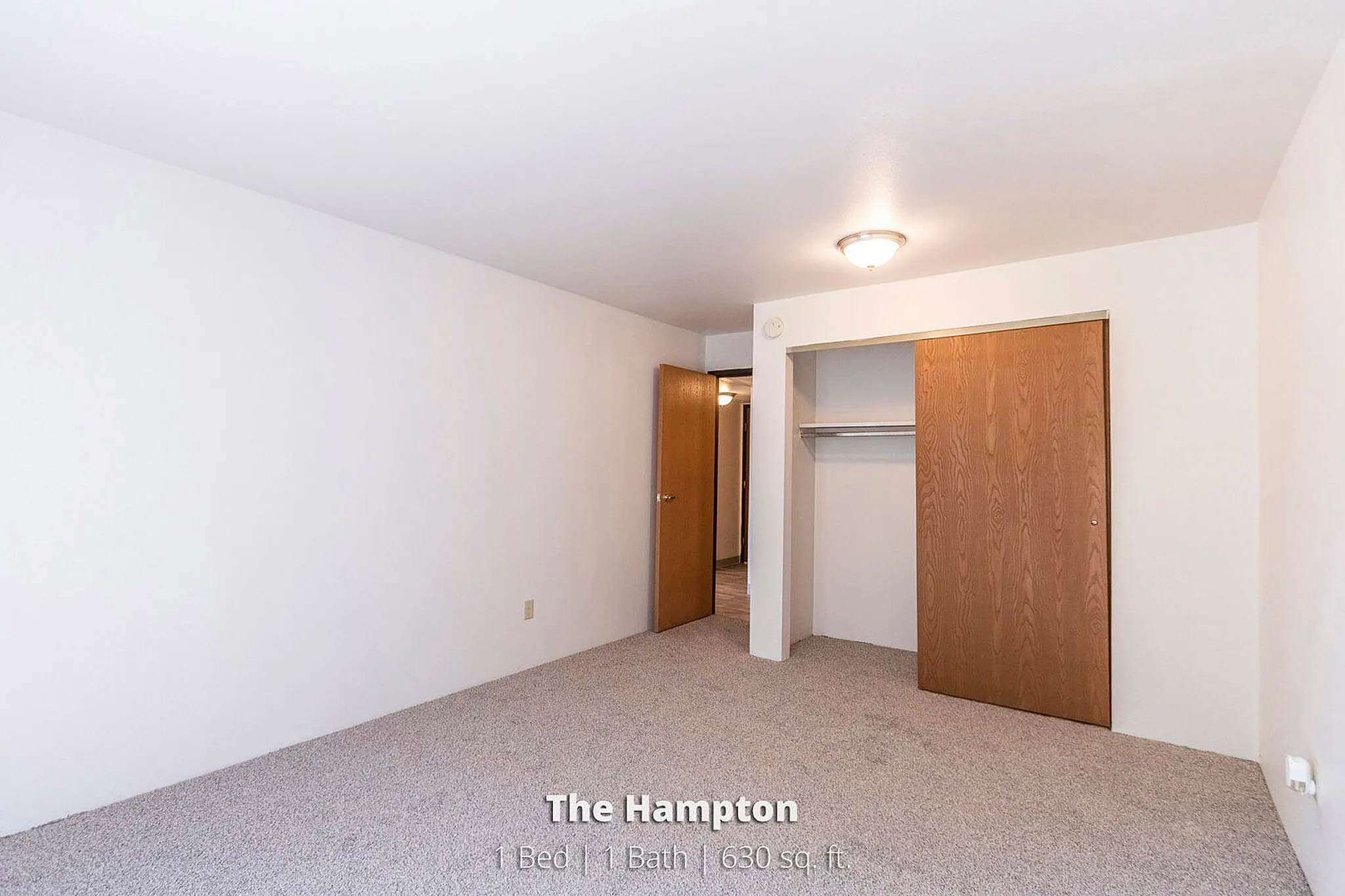 Inviting bedroom interior in The Hampton apartment, featuring cozy carpeting and a spacious closet, perfect for a one-bedroom retreat.