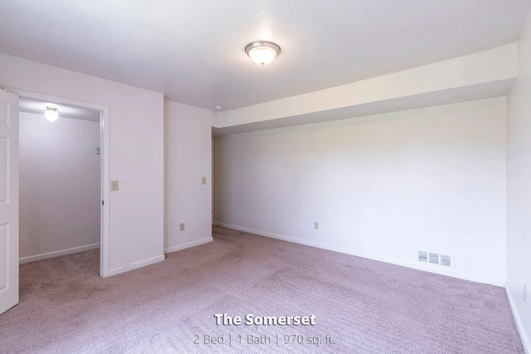 Inviting bedroom with soft carpet and natural light in The Somerset, featuring 2 beds, 1 bath, 970 sq ft.