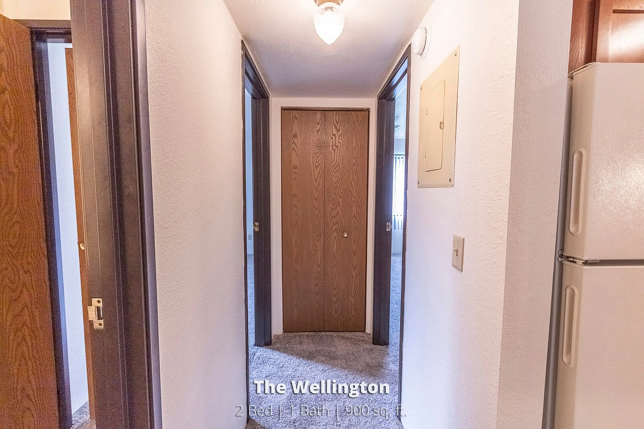 Inviting hallway leading to cozy bedrooms in The Wellington, a 2 Bed 1 Bath 900 sq ft apartment.