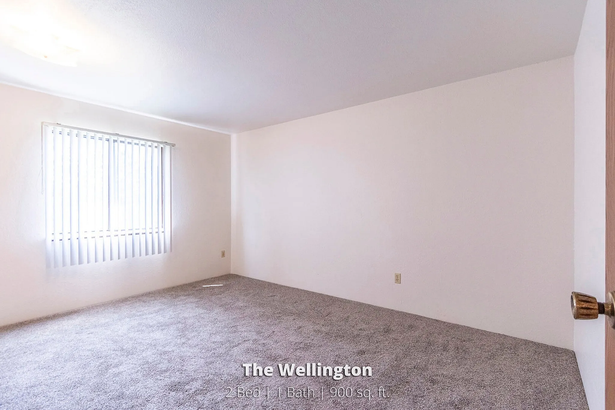 Bright and inviting bedroom in The Wellington apartment, featuring plush carpet and ample natural light, 2 Bed, 1 Bath, 900 sq ft.