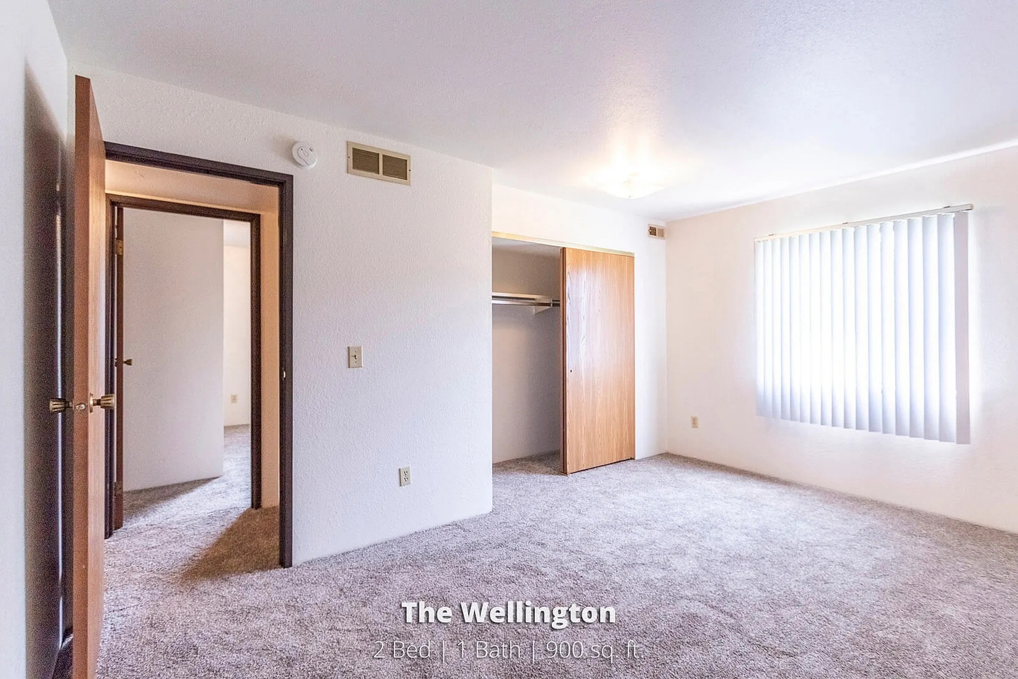 Bright and airy bedroom in The Wellington apartment, featuring 2 beds, 1 bath, and a spacious 900 sq ft layout.
