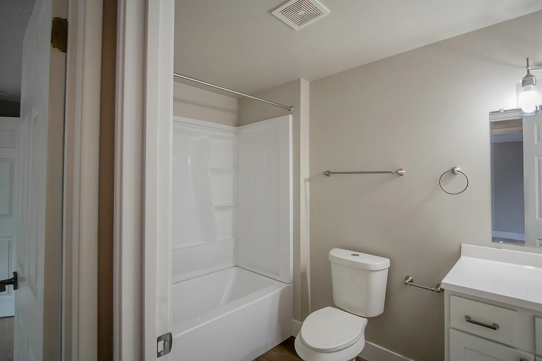 Bright and modern bathroom featuring a pristine bathtub, sleek vanity, and elegant fixtures, offering a fresh and inviting atmosphere.