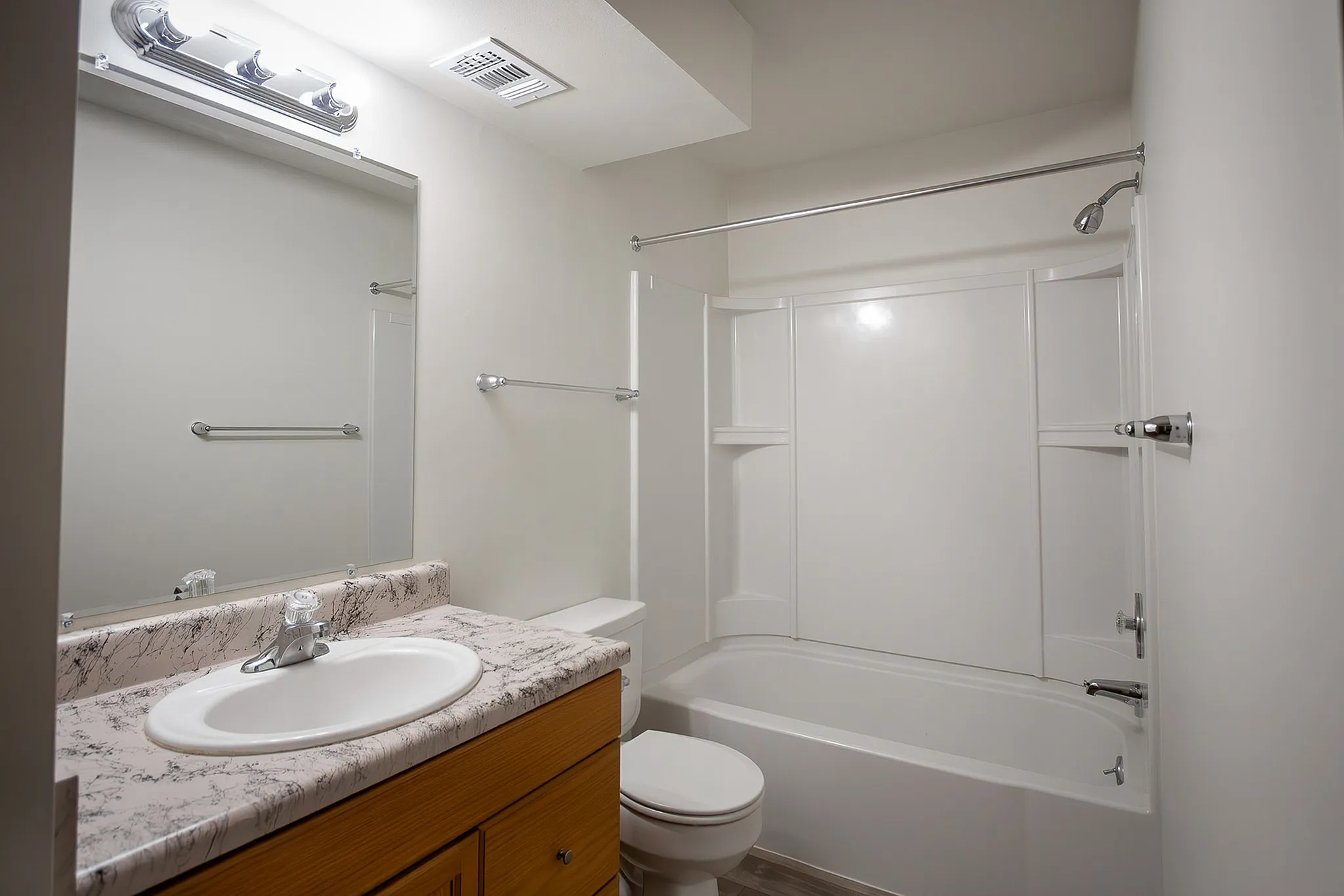 Contemporary bathroom with a sleek marble countertop, spacious bathtub, and modern fixtures.