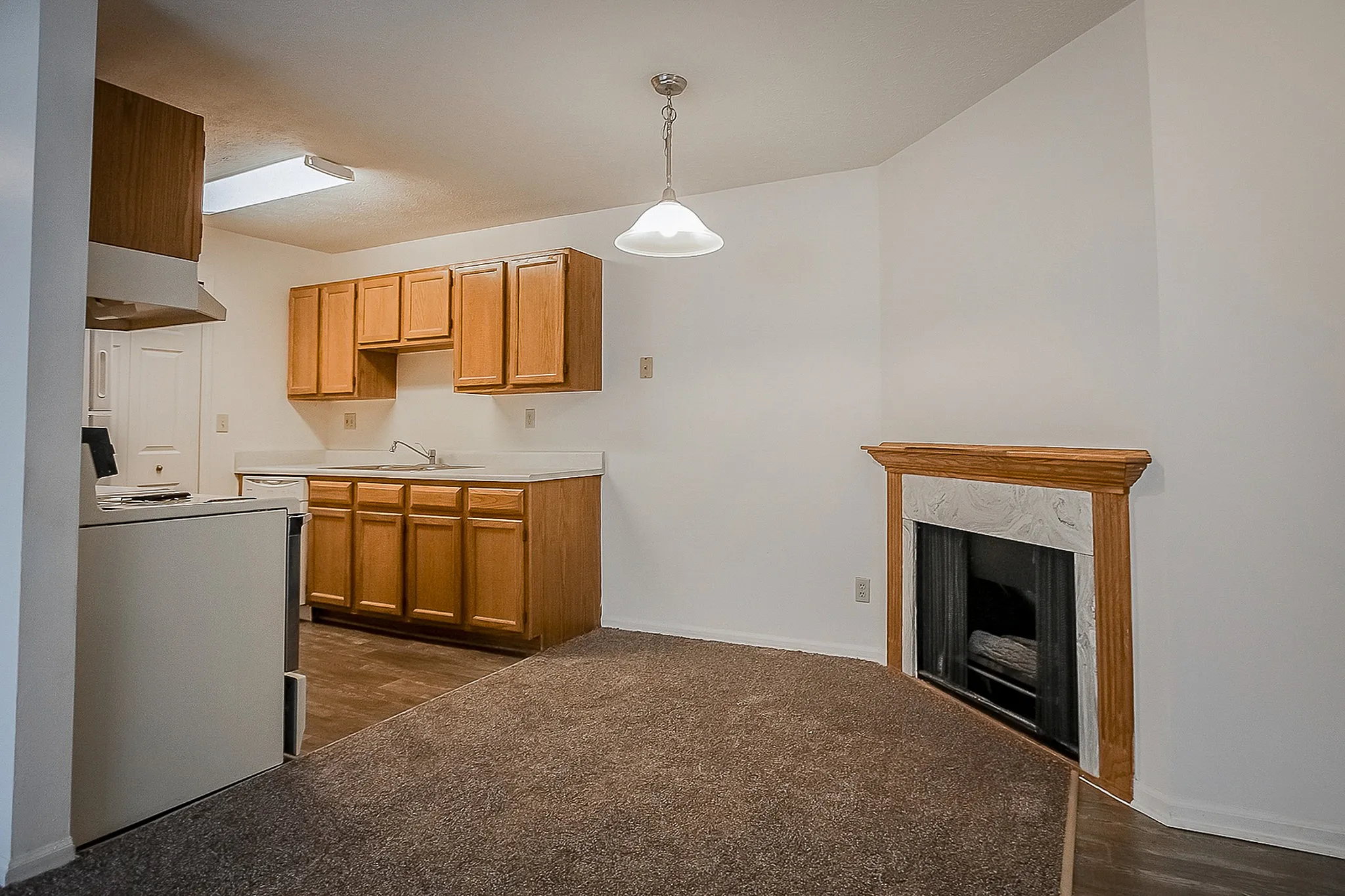 Inviting kitchen area with warm wooden cabinets, sleek countertops, and a cozy fireplace enhancing the living space.