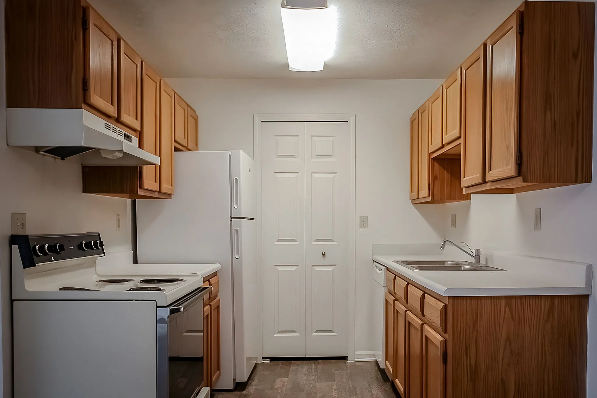Inviting kitchen with warm wooden cabinets, modern appliances, and spacious countertops offering a perfect culinary space.
