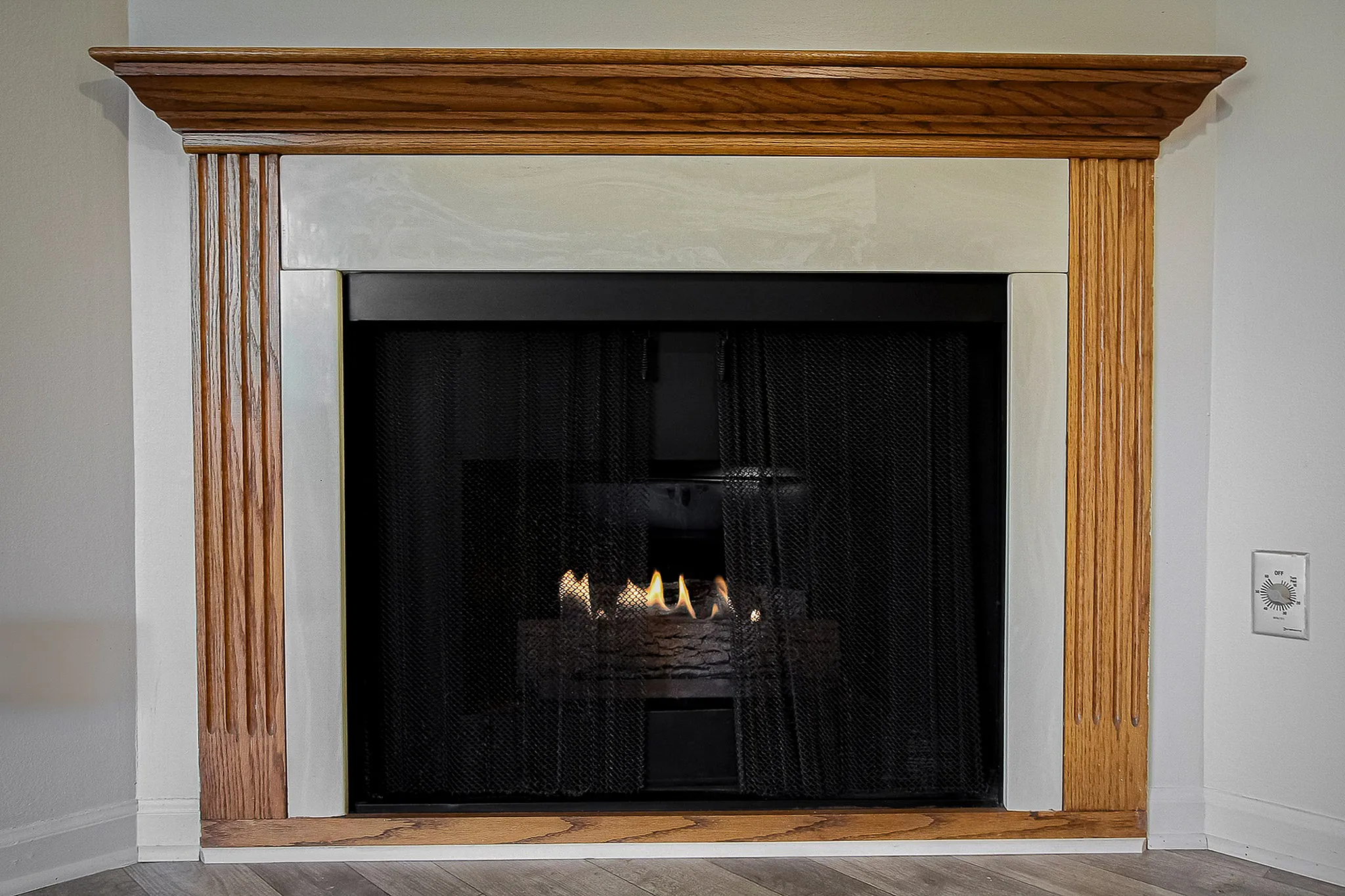 Elegant fireplace with a warm, inviting glow, framed by rich wooden accents, perfect for cozy living spaces.