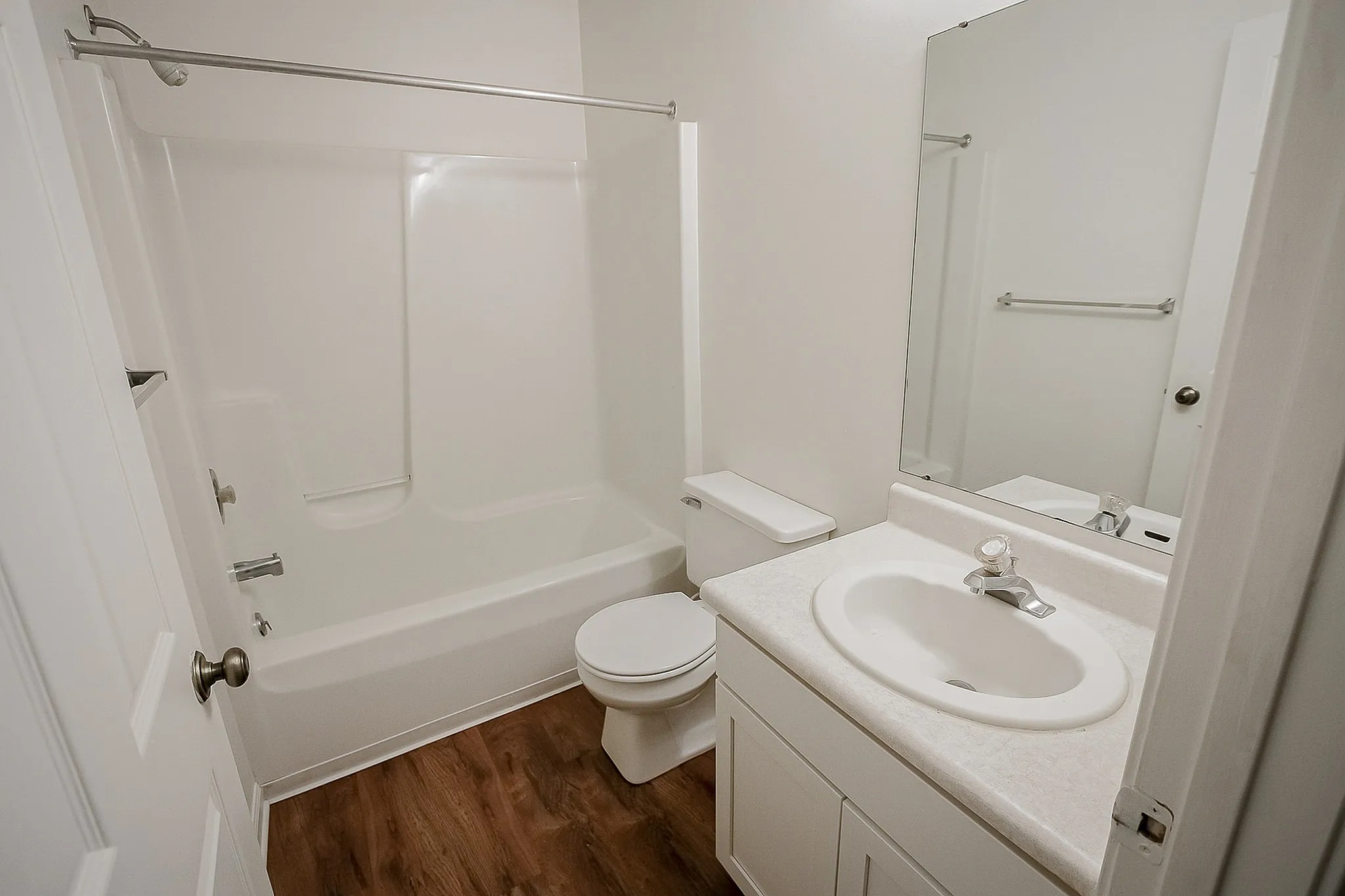 Sleek and modern bathroom featuring a pristine bathtub, elegant vanity, and stylish fixtures.
