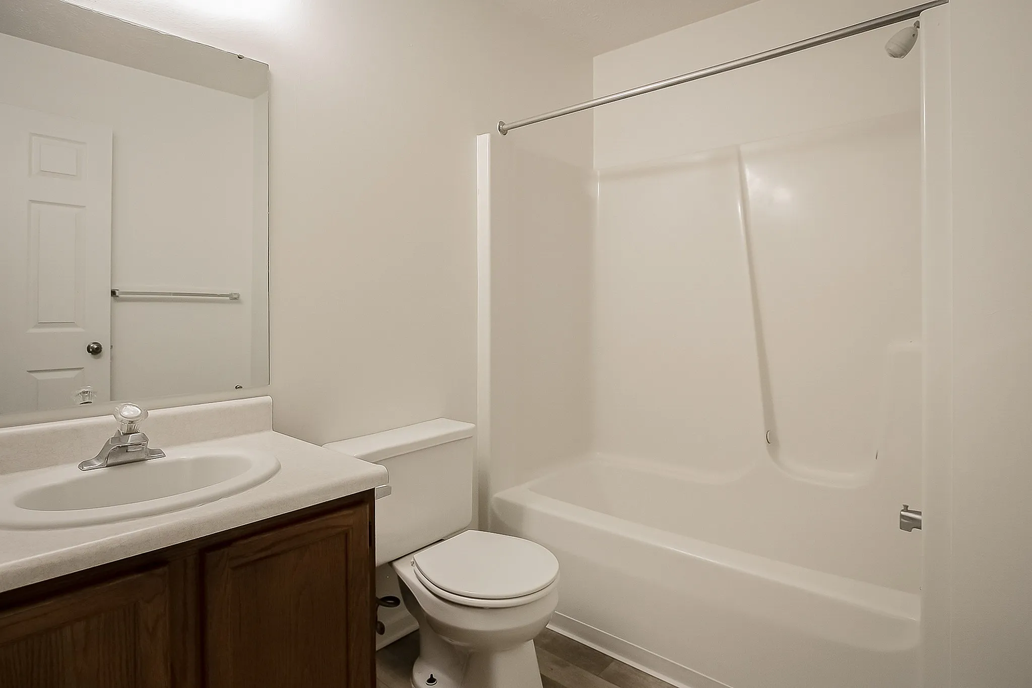 Modern bathroom with clean white bathtub, elegant vanity, and stylish mirror, offering a fresh and inviting atmosphere.