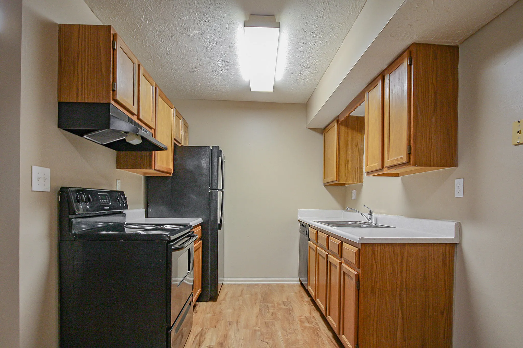 Inviting kitchen featuring modern black appliances, sleek countertops, and ample wooden cabinetry.
