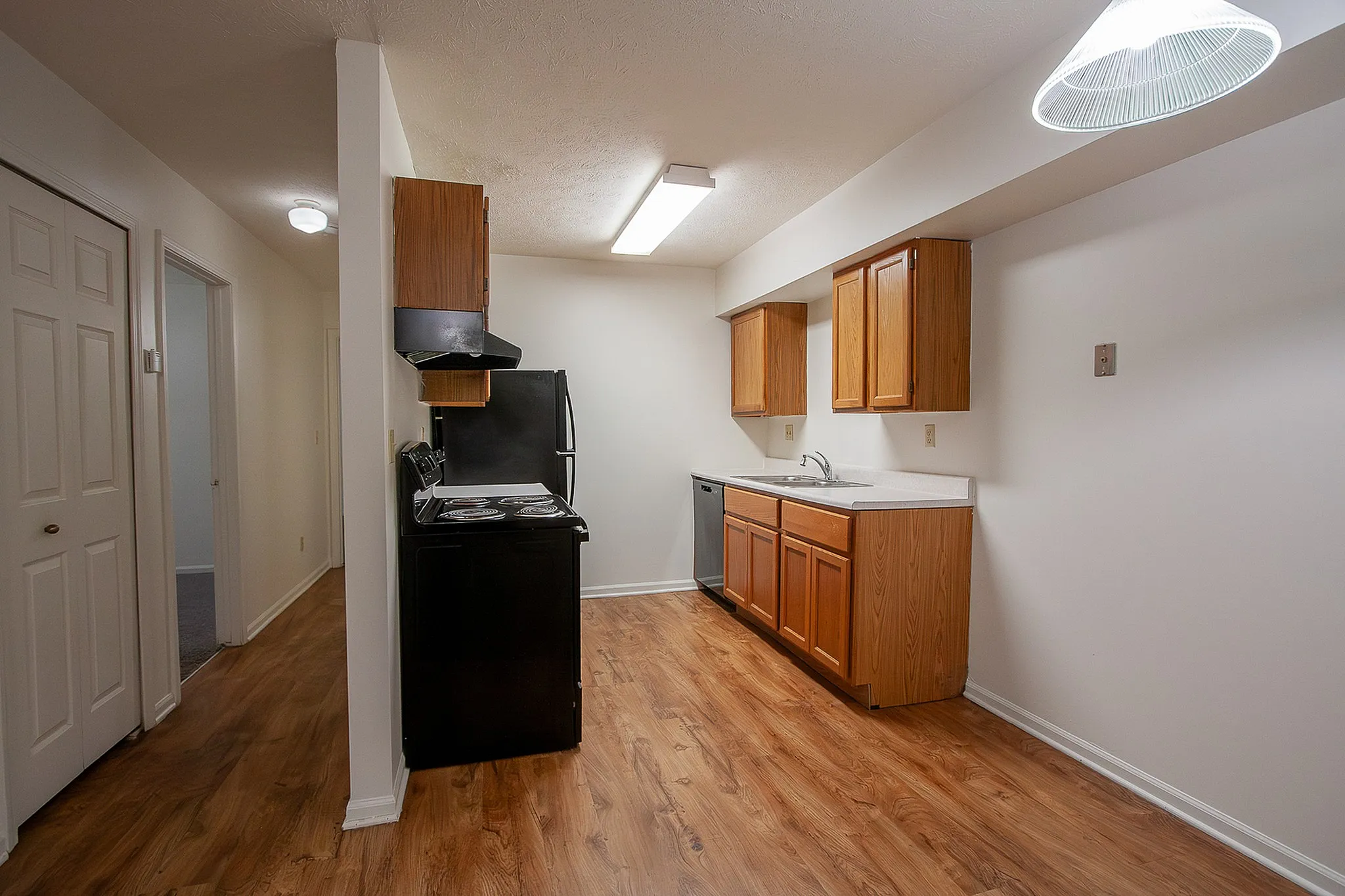 Inviting kitchen with modern appliances, elegant wooden cabinetry, and warm wood flooring, offering a blend of comfort and functionality.