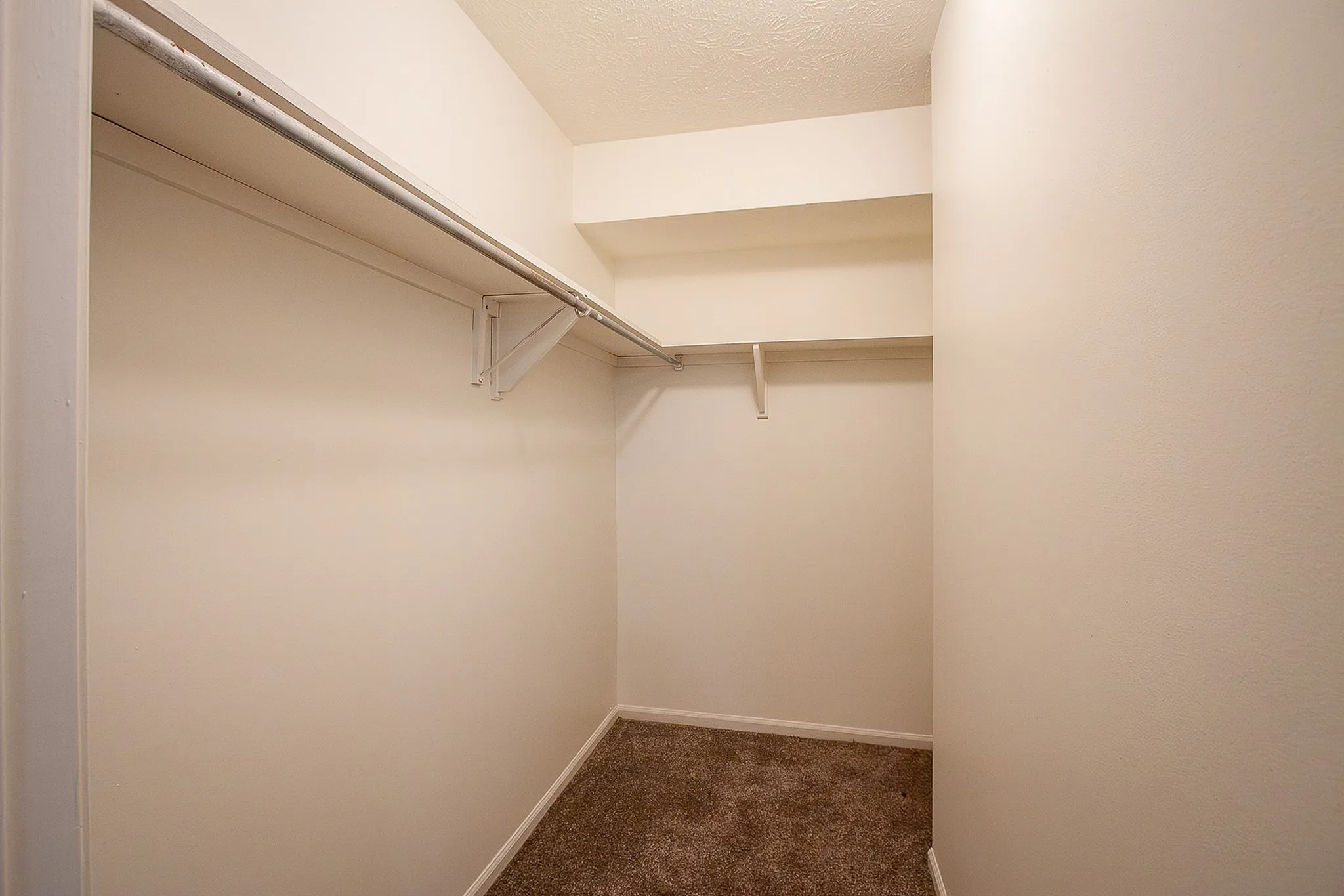 Spacious walk-in closet with ample shelving and elegant design, perfect for maximizing stylish storage solutions.
