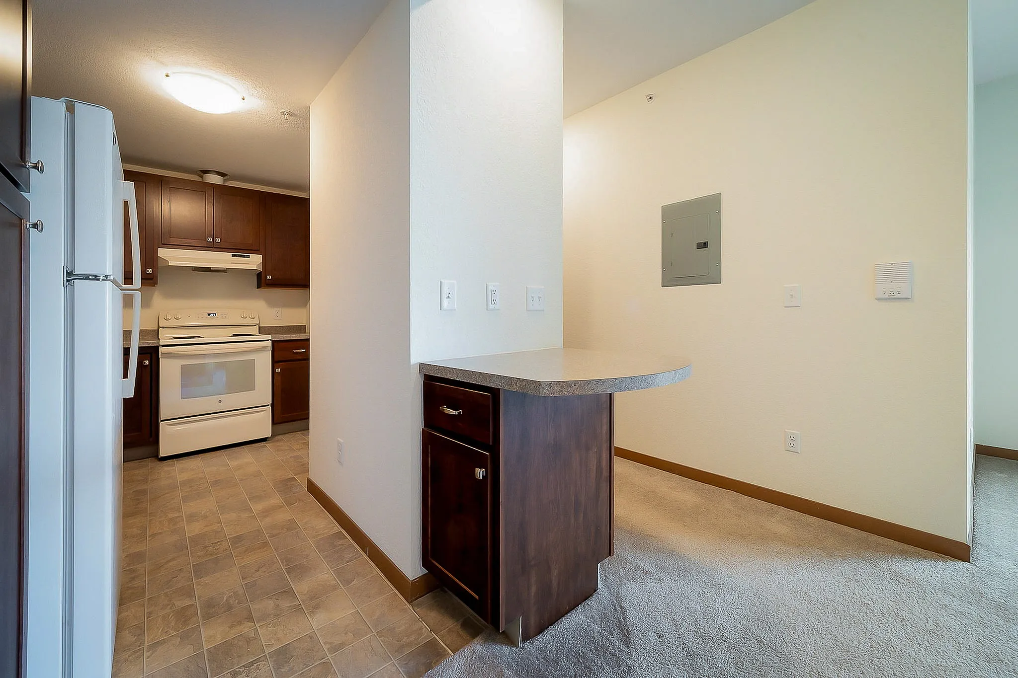 Inviting kitchen with modern appliances, sleek cabinetry, and a convenient breakfast bar in a cozy apartment setting.