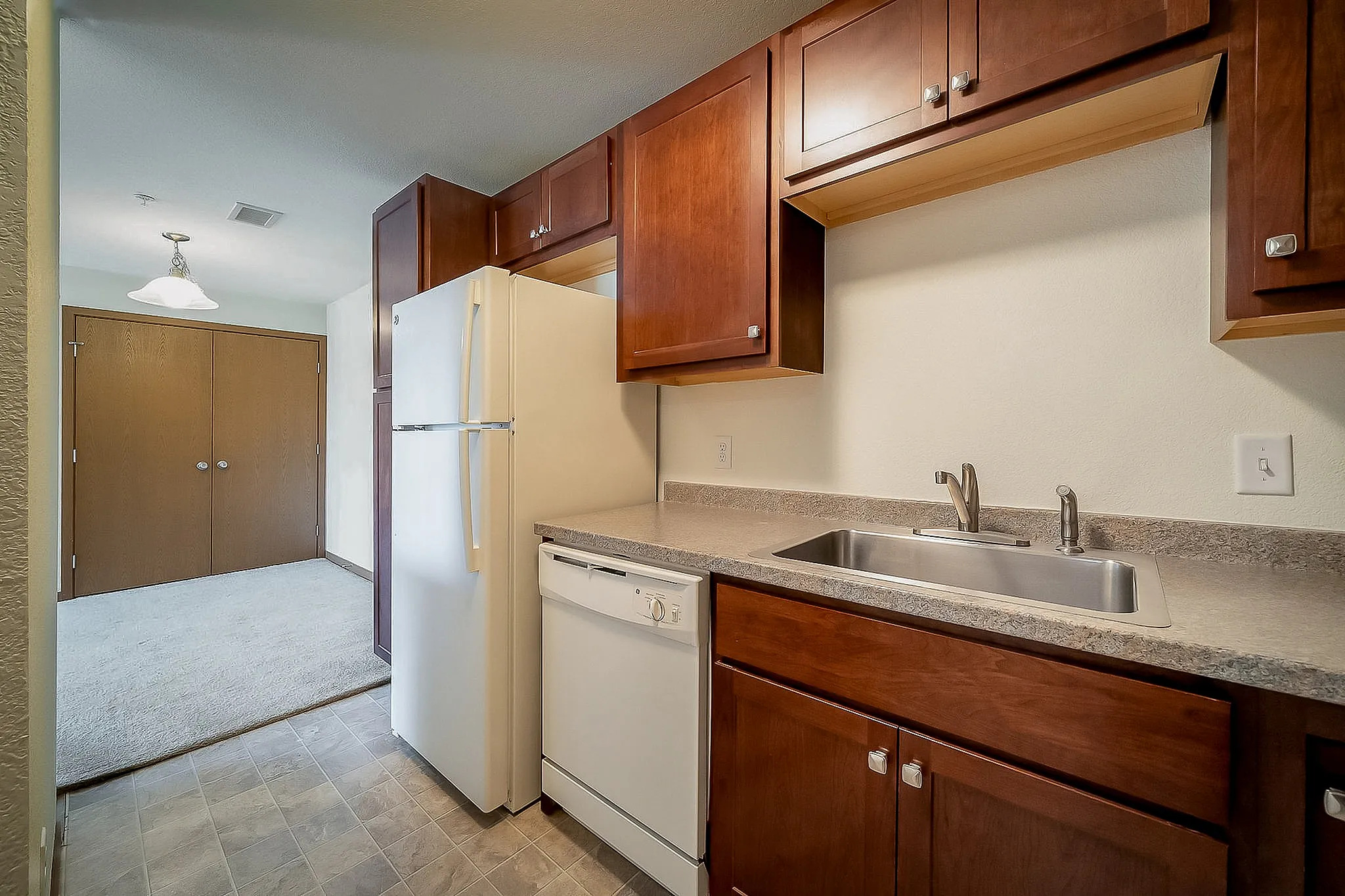 Inviting kitchen with warm wooden cabinets, modern appliances, and a sleek countertop.