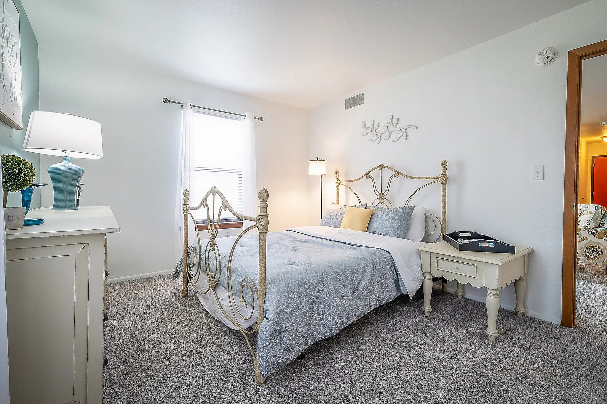 Charming bedroom with elegant wrought iron bed frame, cozy ambiance, and soft natural light.