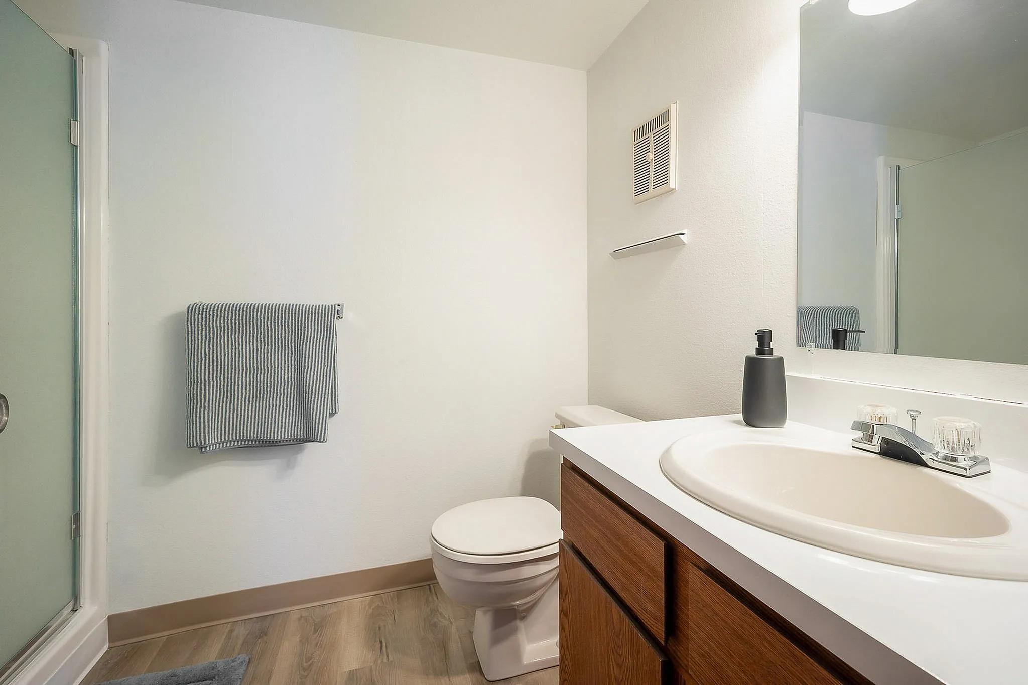 Modern bathroom with sleek fixtures, wood cabinetry, and soft lighting, perfect for relaxation.