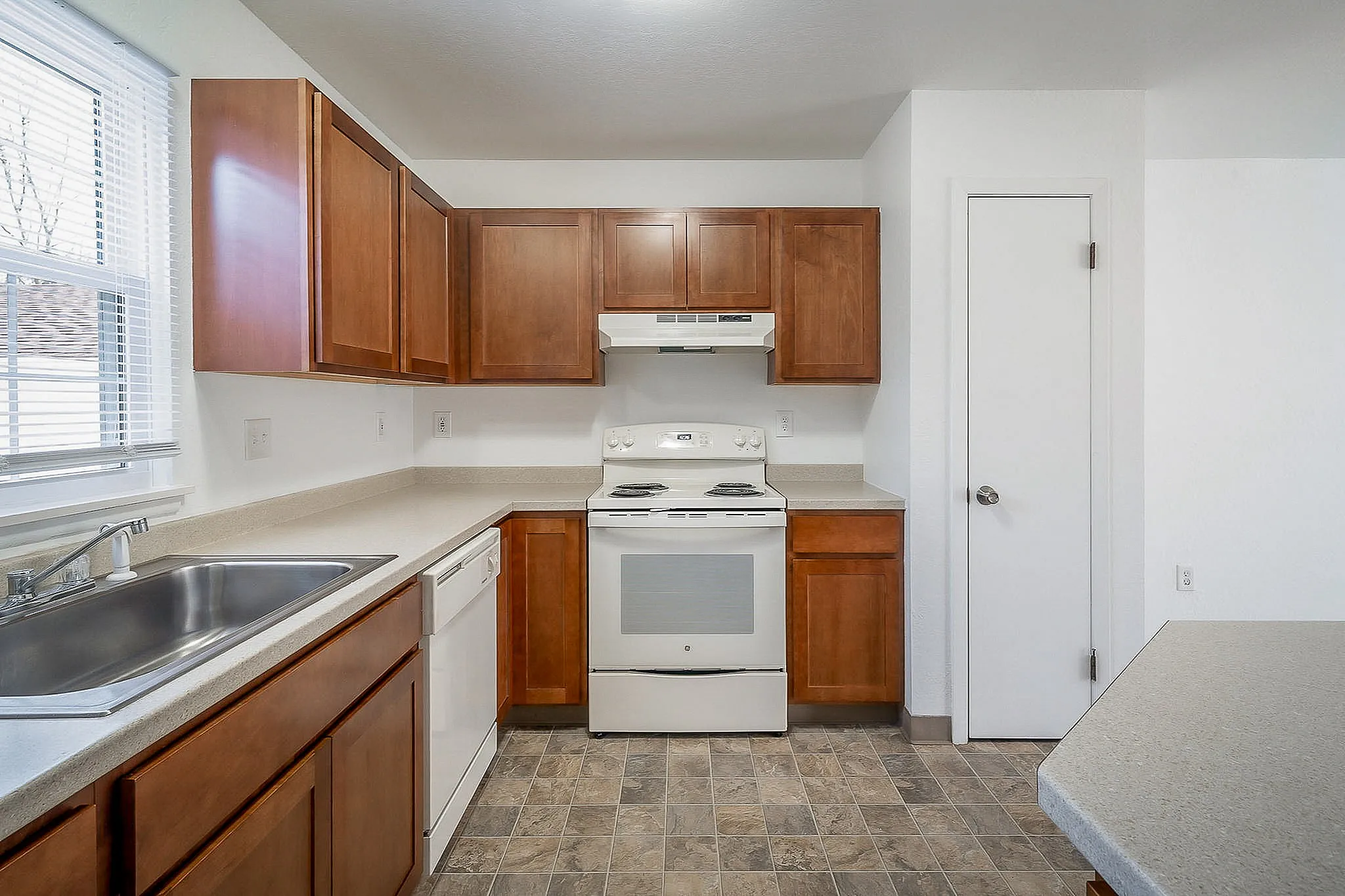 Bright and inviting kitchen featuring modern appliances, ample wooden cabinetry, and a cozy layout perfect for cooking enthusiasts.
