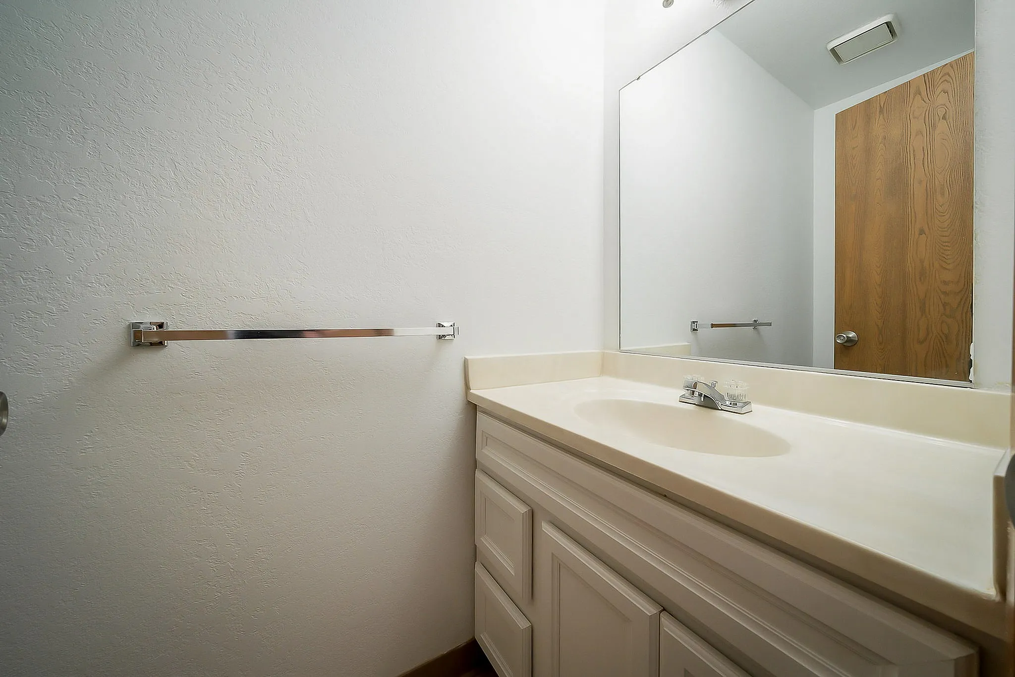 Modern bathroom showcasing a sleek white vanity with a large mirror, perfect for a fresh and clean aesthetic.