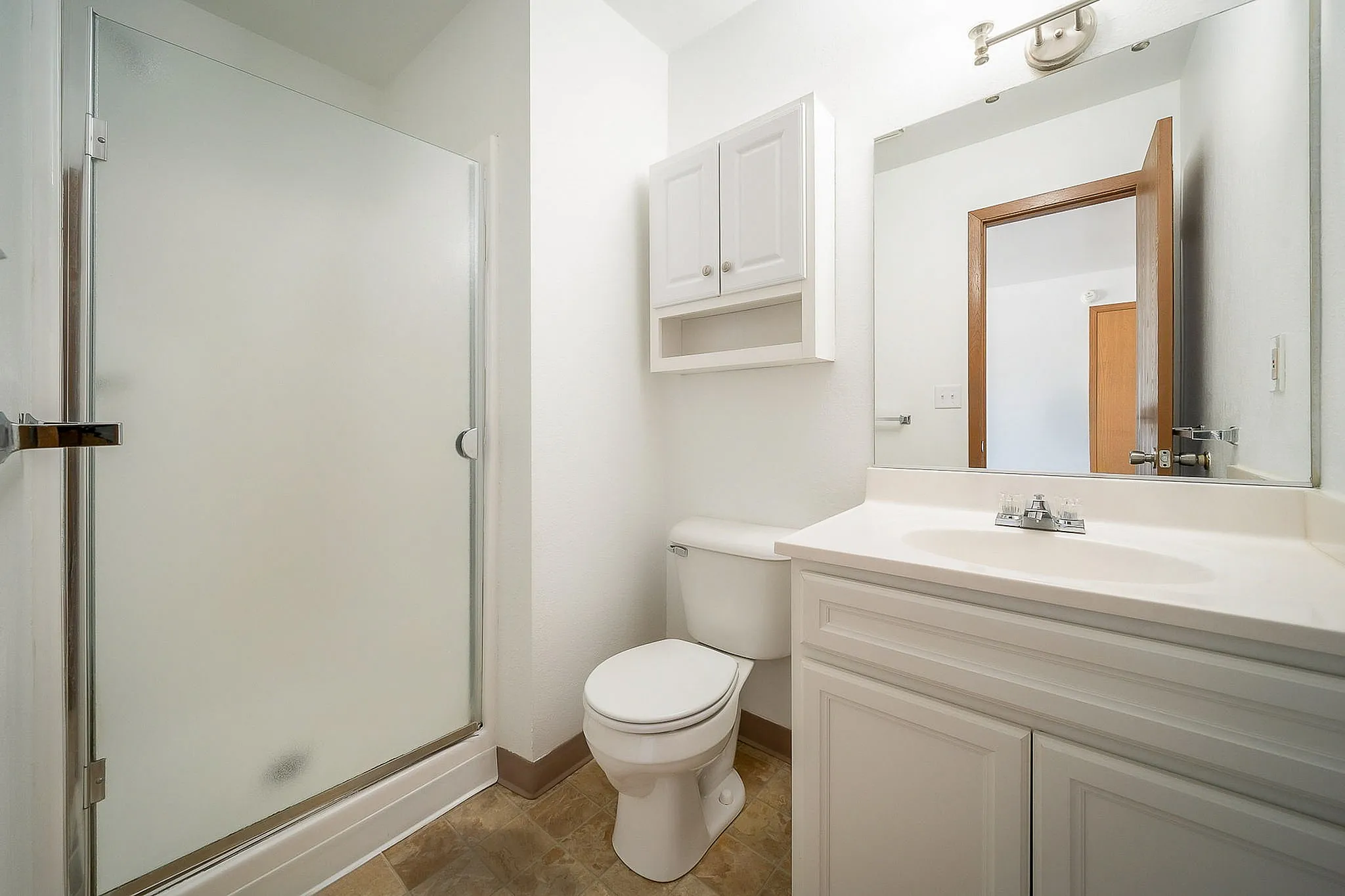 Sleek and modern bathroom featuring a spacious walk-in shower, elegant vanity, and ample cabinet storage.