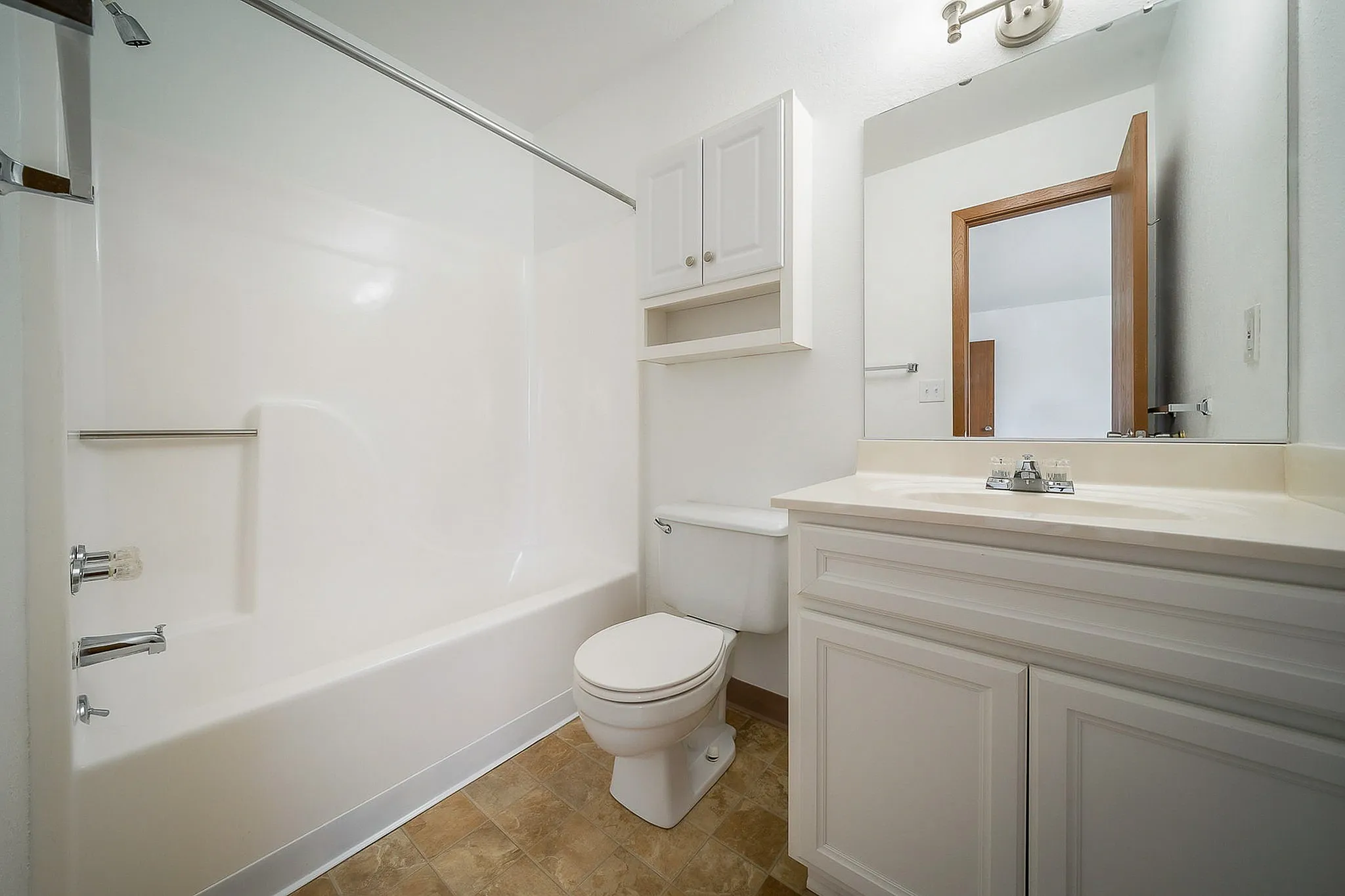 Elegant and spacious bathroom with modern fixtures, featuring a pristine bathtub, sleek vanity, and ample storage space.