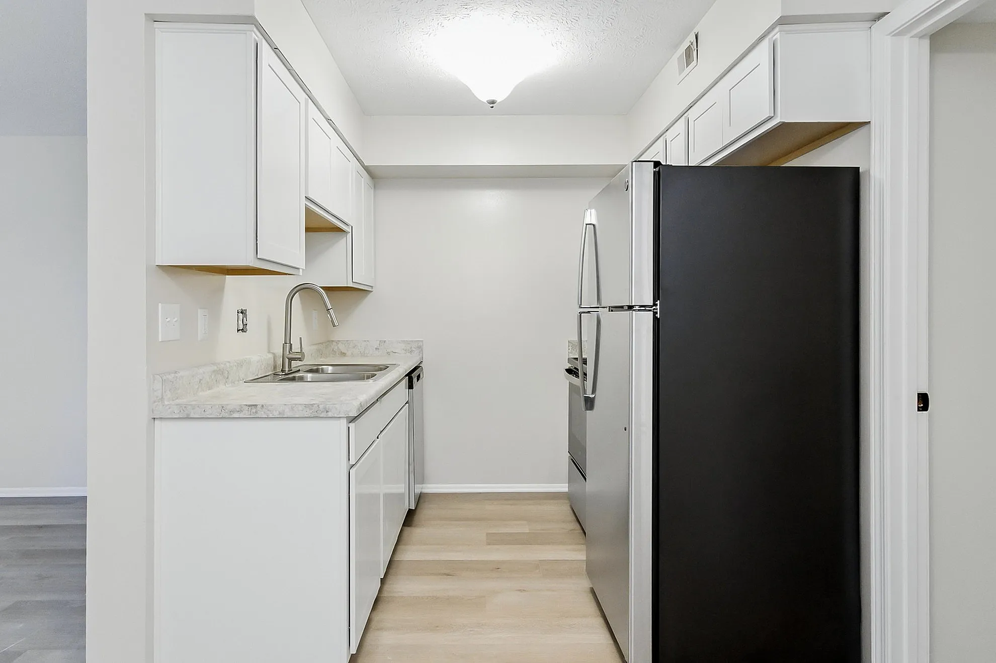 Modern kitchen with sleek appliances, bright cabinetry, and elegant marble countertops.