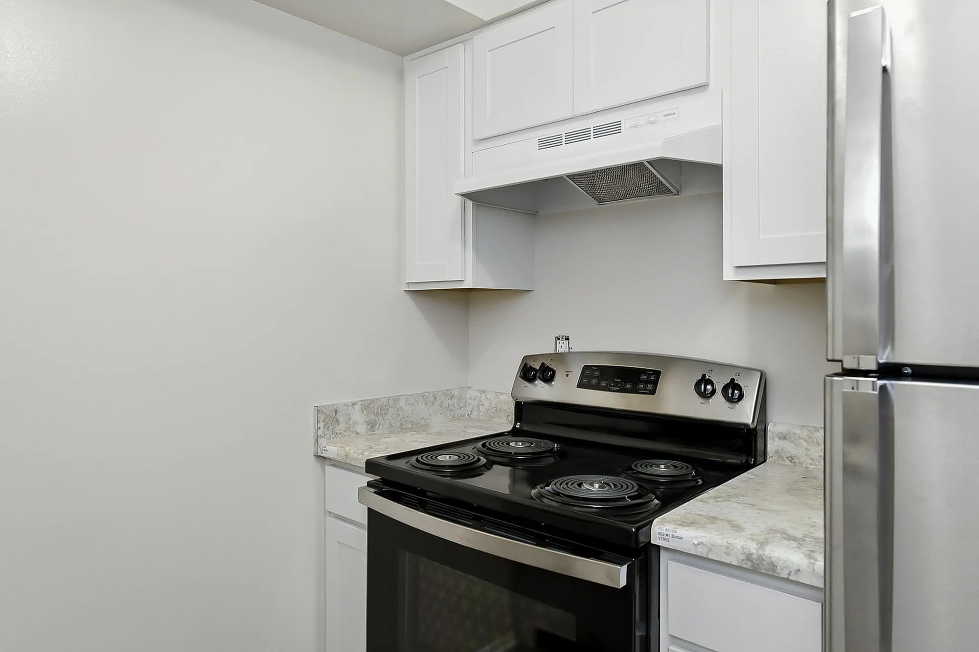 Sleek kitchen with modern appliances, featuring white cabinetry and marble countertops for a contemporary touch.