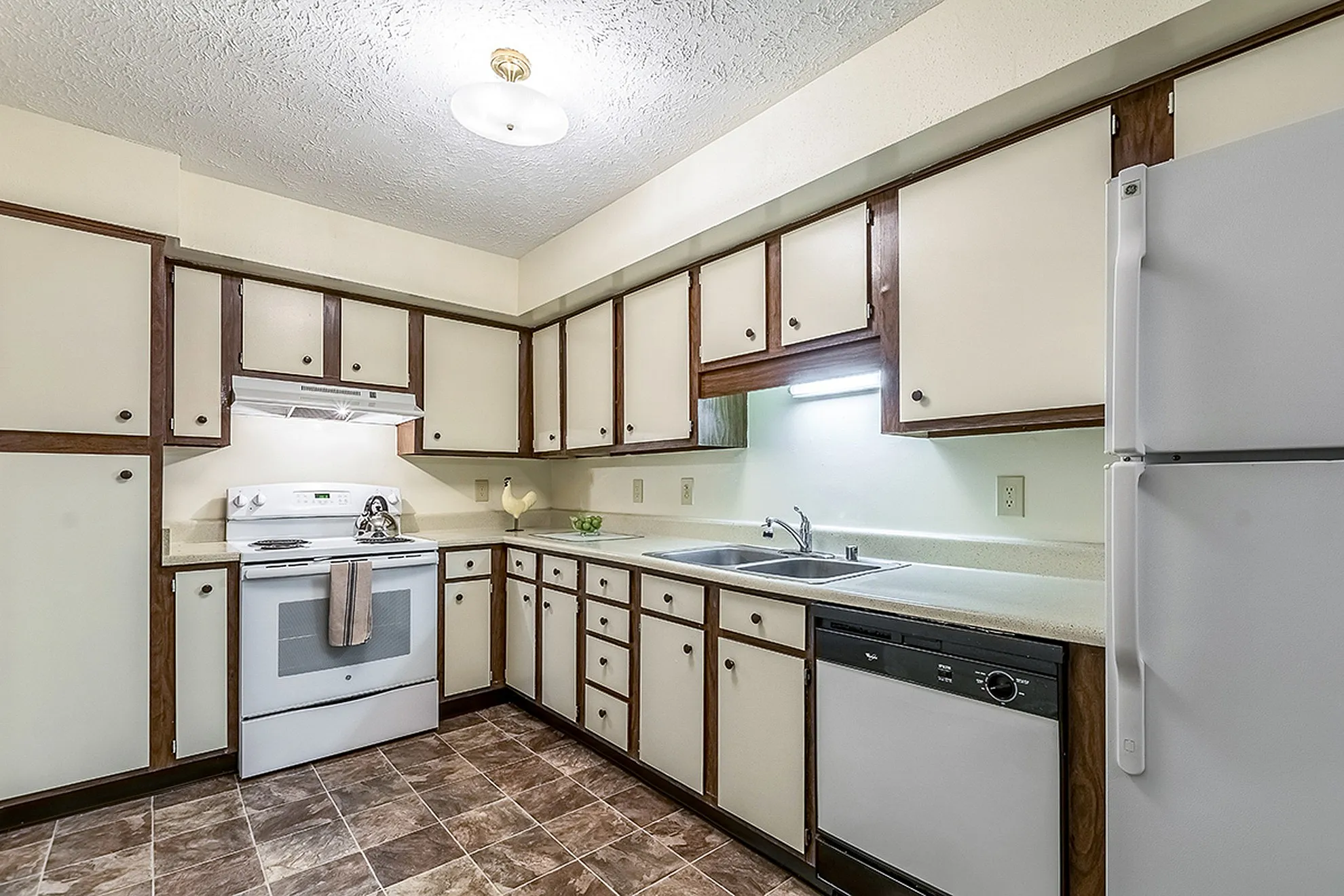 Charming kitchen with ample cabinetry, modern appliances, and chic tile flooring offering functionality and style.