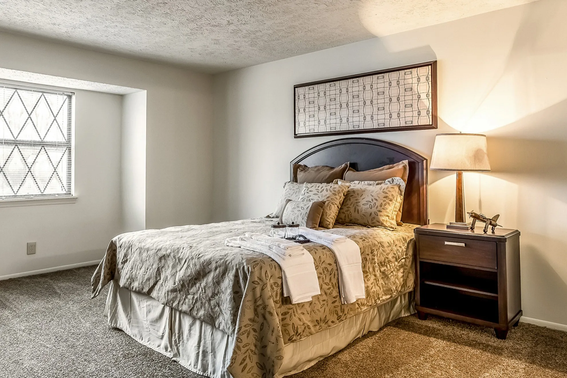 Elegant bedroom with plush bedding, stylish wall art, and ambient lighting for a cozy atmosphere.