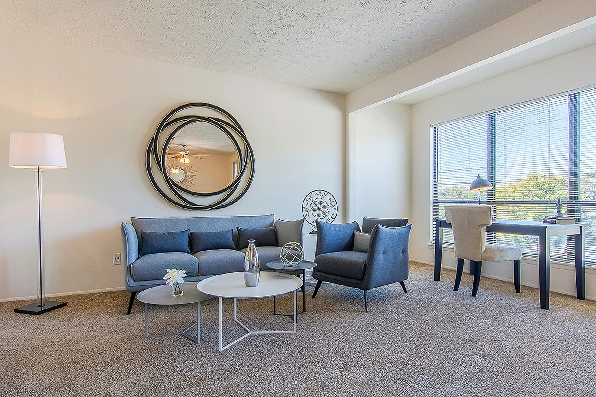 Bright and modern living room with contemporary furniture, elegant decor, and a large window offering abundant natural light.