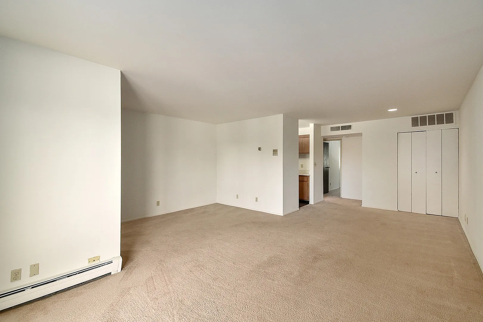 Spacious open floor plan in a modern apartment featuring neutral tones and versatile design possibilities.