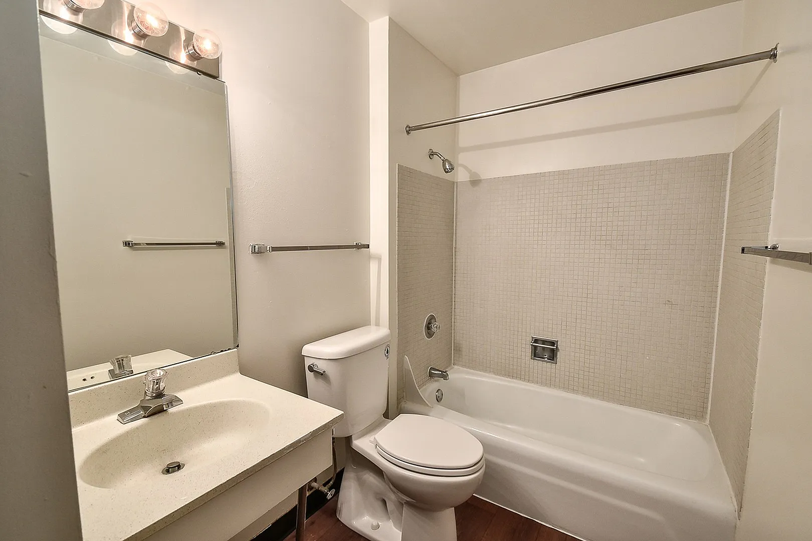 Modern bathroom with sleek fixtures, featuring a spacious vanity, bright lighting, and a pristine bathtub with elegant tiled walls.