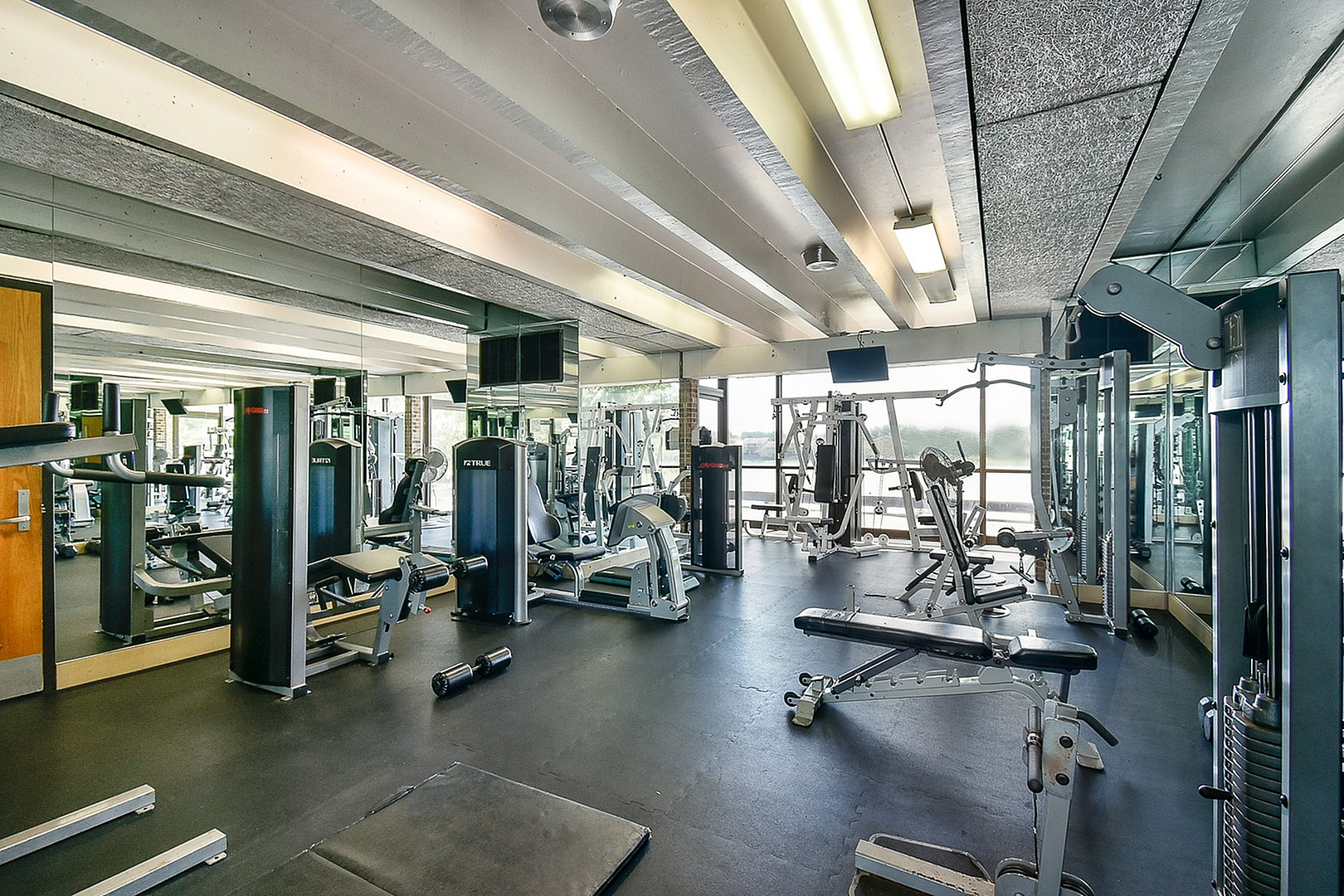 Modern fitness center with state-of-the-art equipment, mirrored walls, and ample workout space.