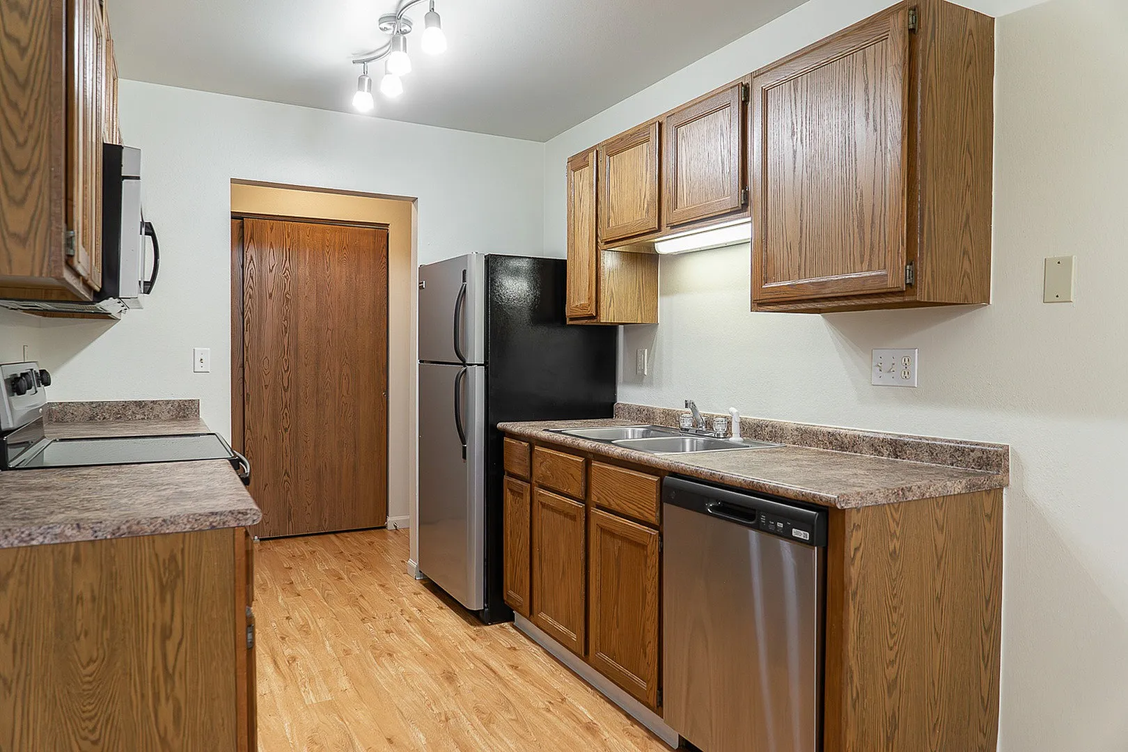 Modern kitchen with stylish wooden cabinetry, efficient stainless steel appliances, and elegant countertop lighting.
