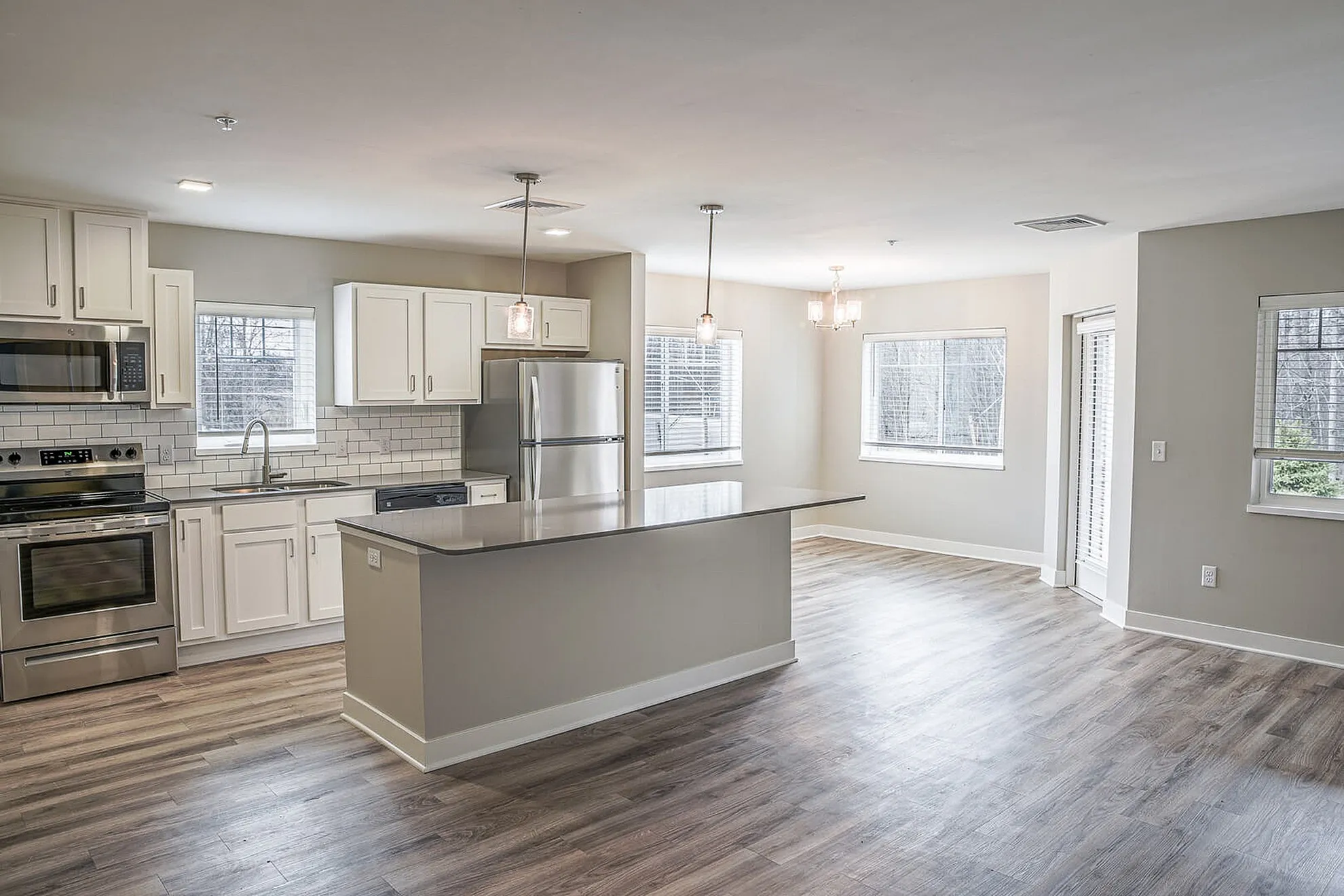 Chic open-concept kitchen and living area with modern appliances, elegant cabinetry, and abundant natural light.