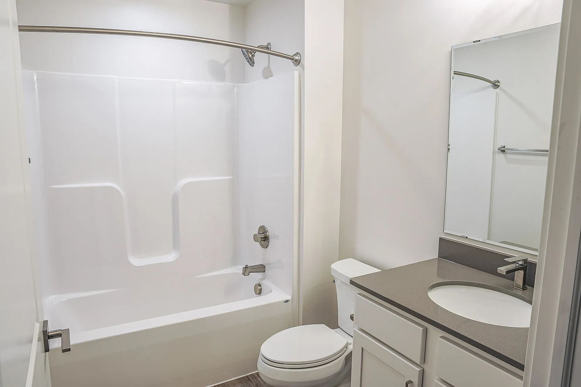 Modern bathroom with sleek fixtures, featuring a spacious bathtub, elegant vanity, and a large mirror for a luxurious feel.