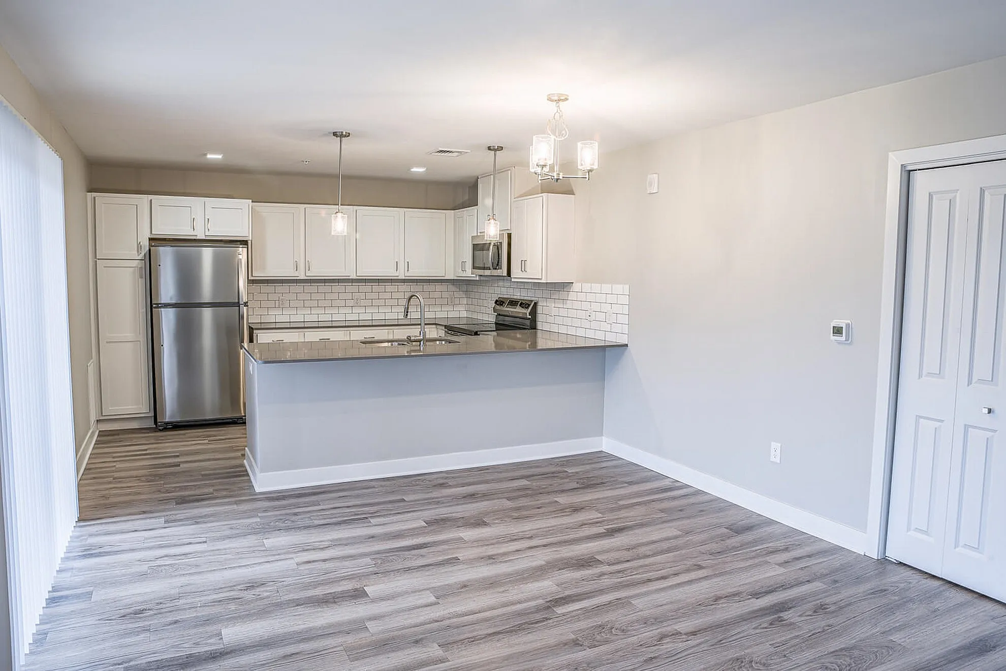 Modern kitchen design with sleek stainless steel appliances, stylish white cabinetry, and elegant lighting accents.