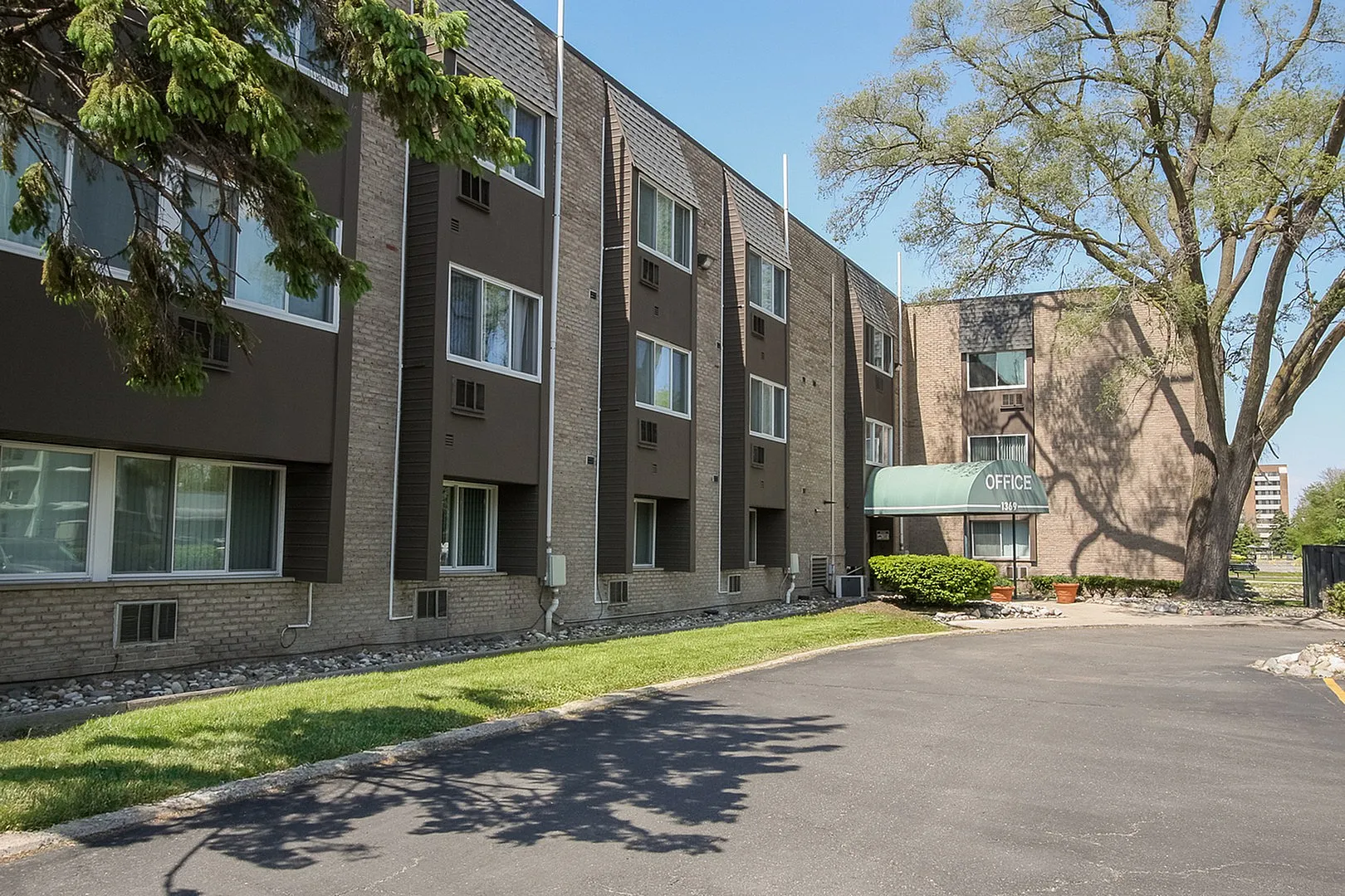 Charming residential building with modern architecture, featuring lush landscaping and a welcoming front office.