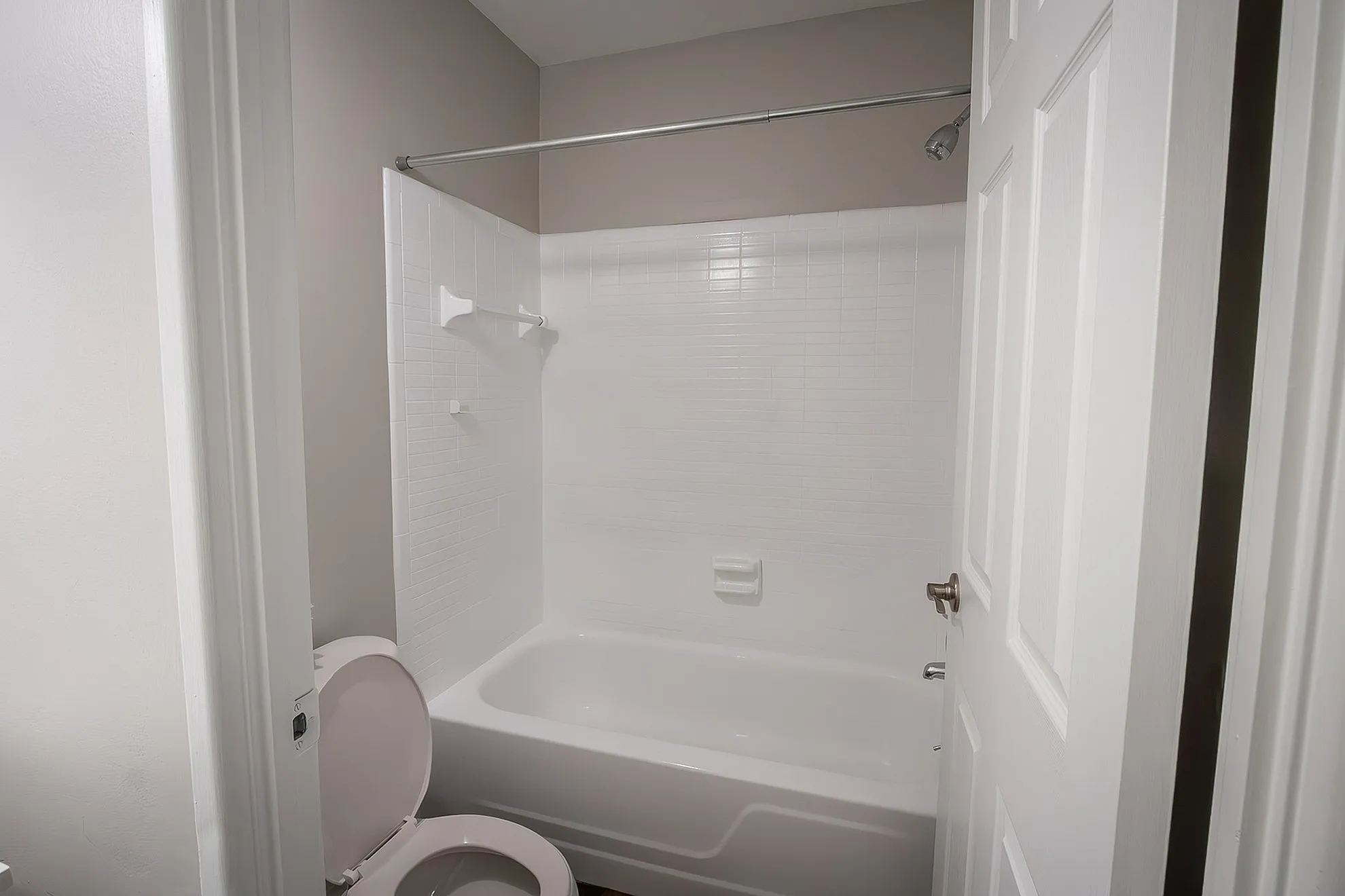 Modern bathroom with a pristine white bathtub and sleek fixtures, ideal for relaxation.