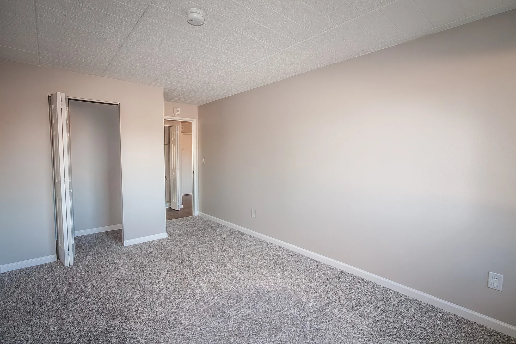Bright and spacious room with soft carpeting and neutral walls, perfect for versatile design options.