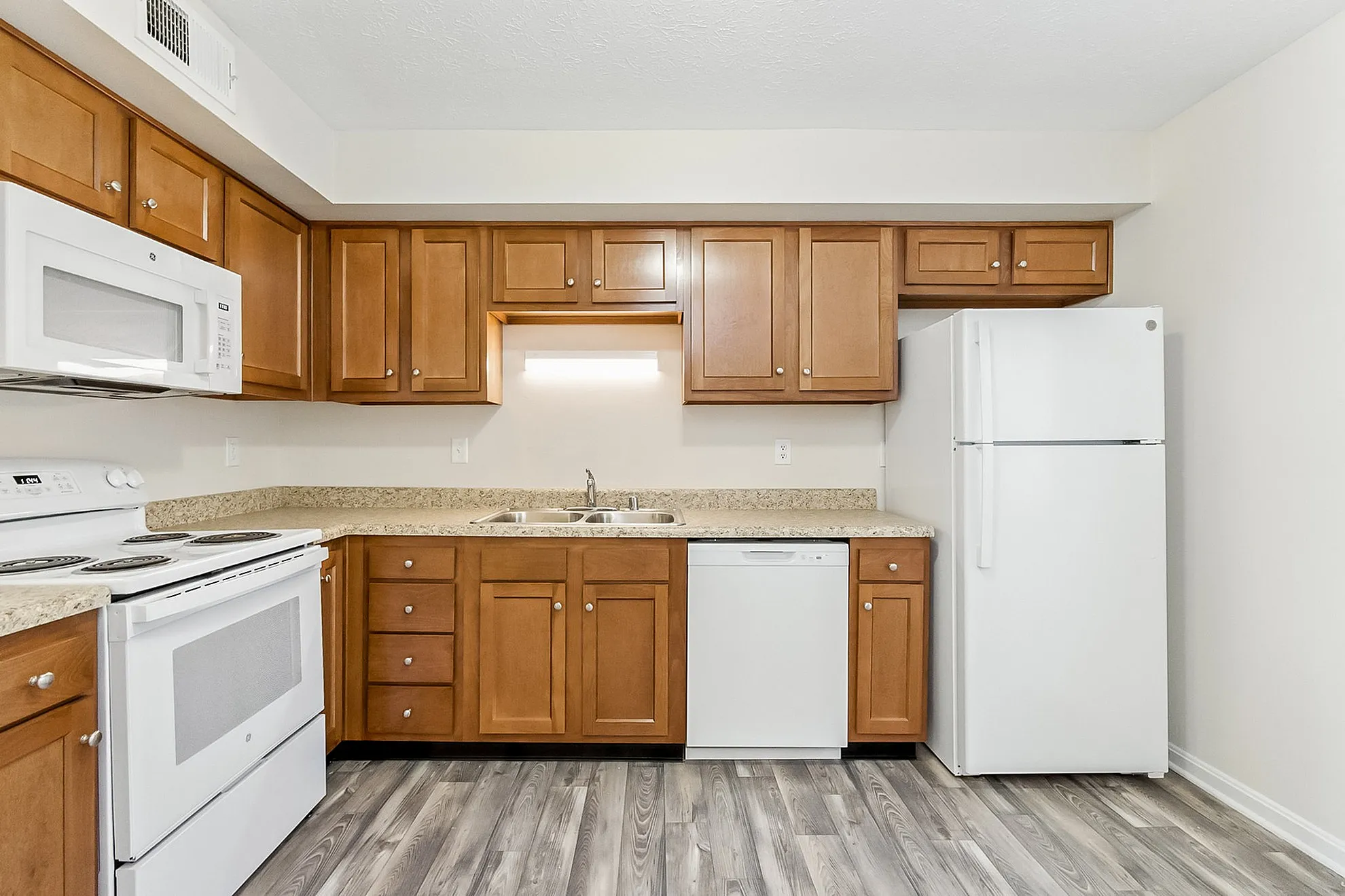 Modern kitchen with elegant wood cabinetry, sleek appliances, and stylish countertops, perfect for culinary enthusiasts.