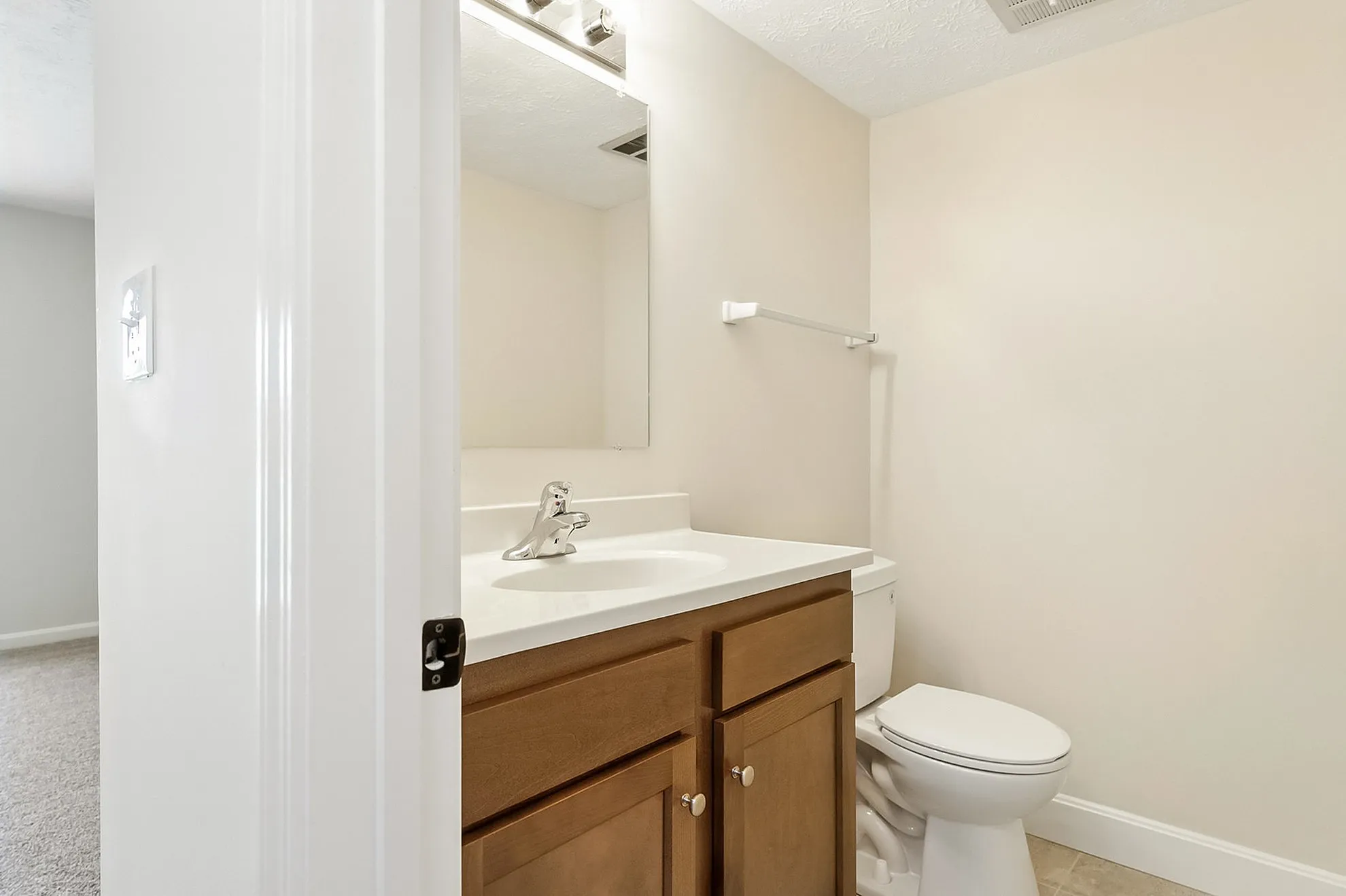 Elegantly designed bathroom featuring a sleek countertop, modern fixtures, and stylish wooden cabinetry.