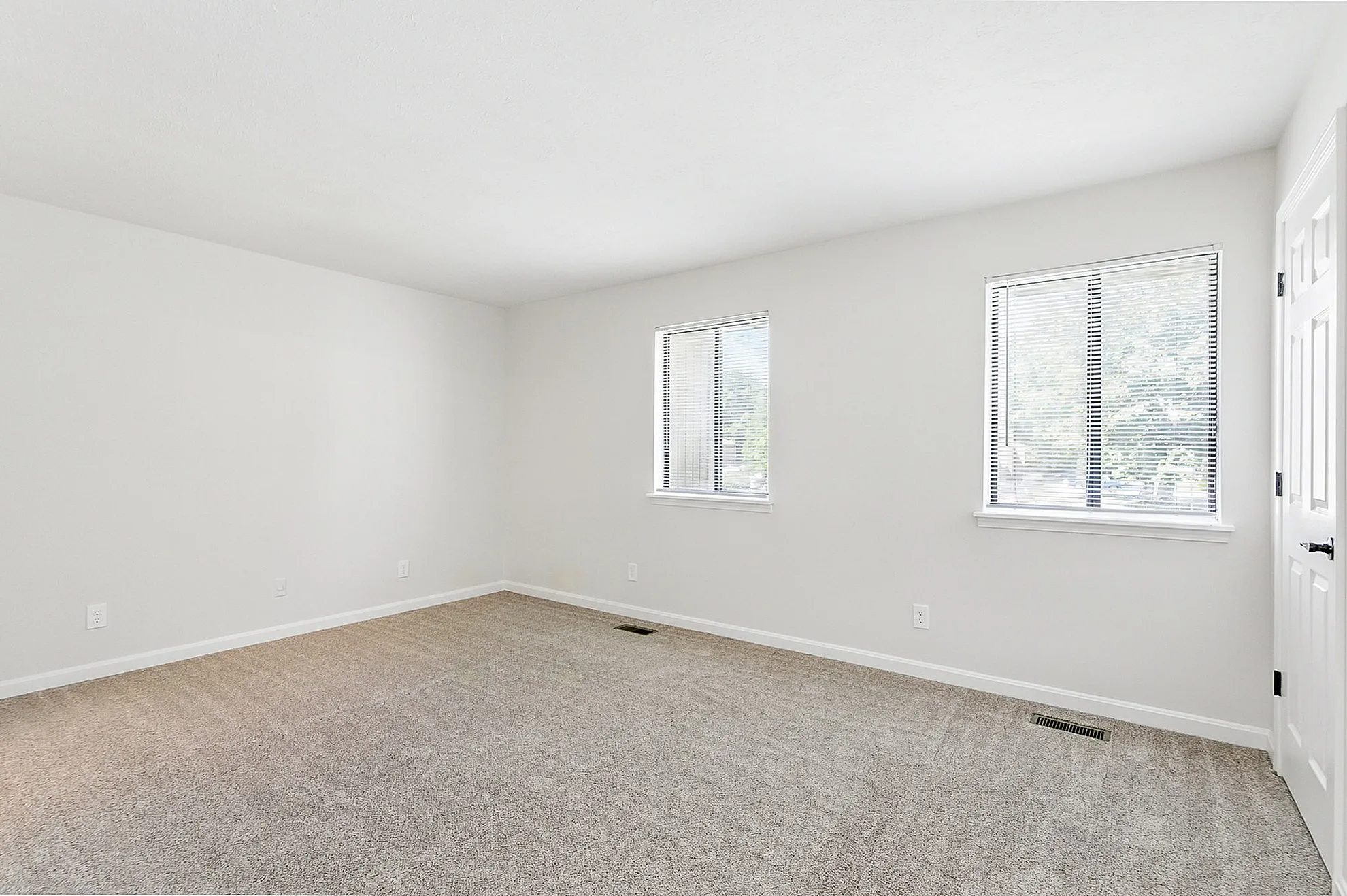 Bright and spacious room with plush carpeting and large windows for abundant natural light.