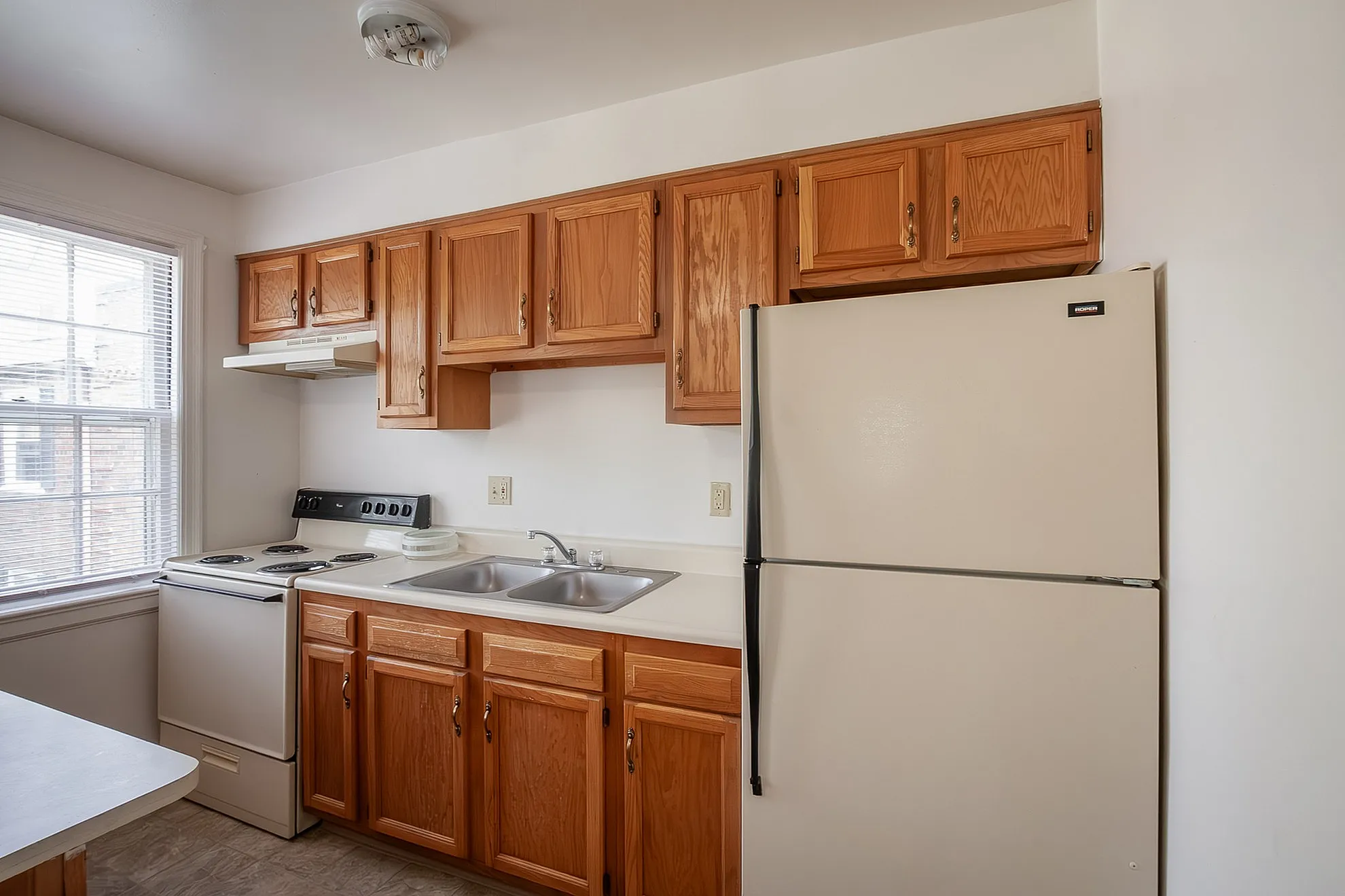 Bright and inviting kitchen with classic wooden cabinets, modern appliances, and ample countertop space.