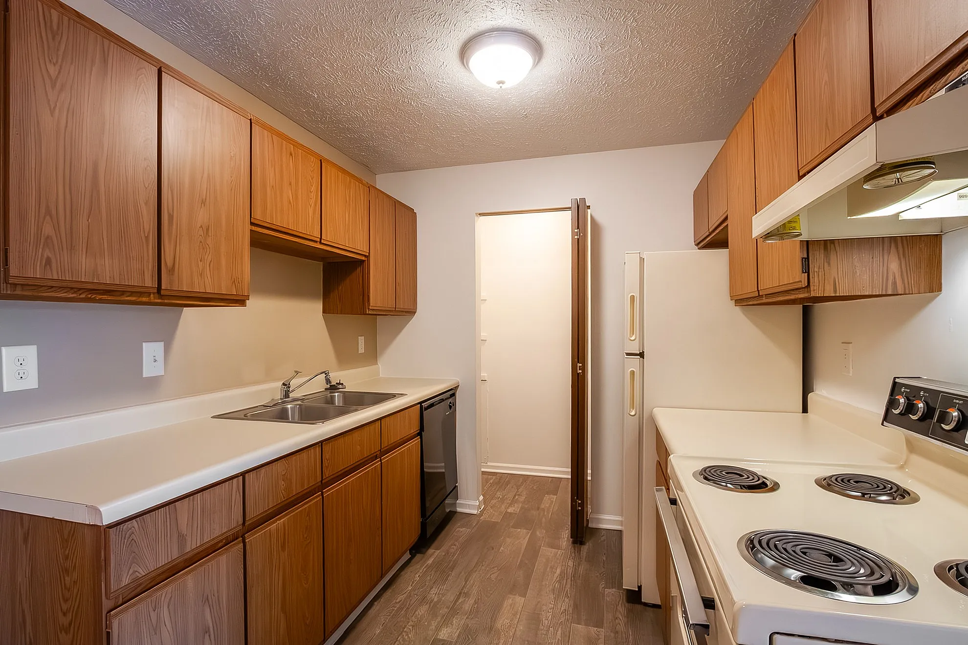 Charming kitchen with warm wooden cabinetry, sleek countertops, and modern appliances, ideal for culinary creations.
