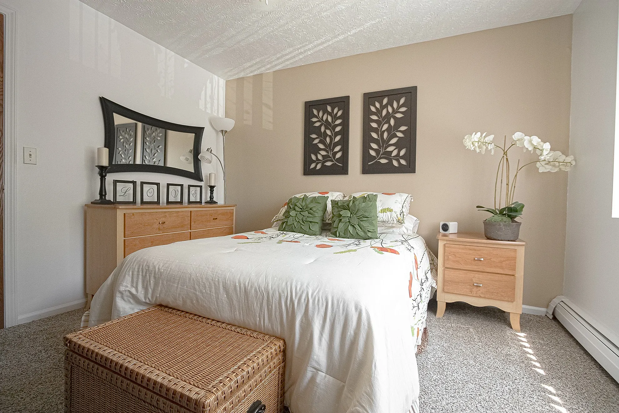 Bright and cozy bedroom with elegant décor, featuring a plush bed with floral bedding, stylish wall art, and a serene atmosphere.