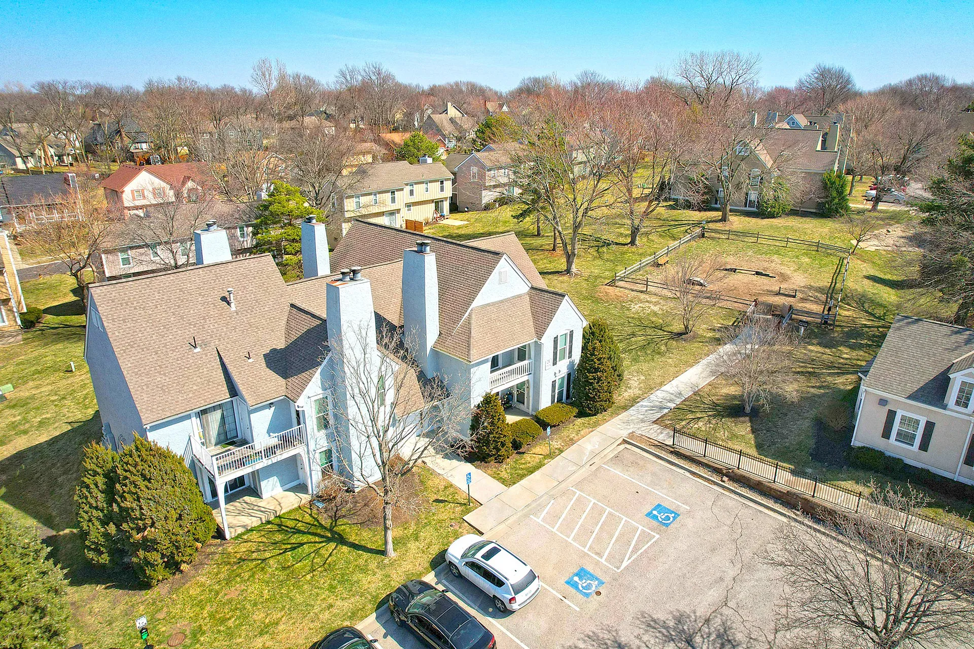 Charming suburban home with a spacious front yard and ample parking in a tranquil neighborhood setting, surrounded by lush trees.