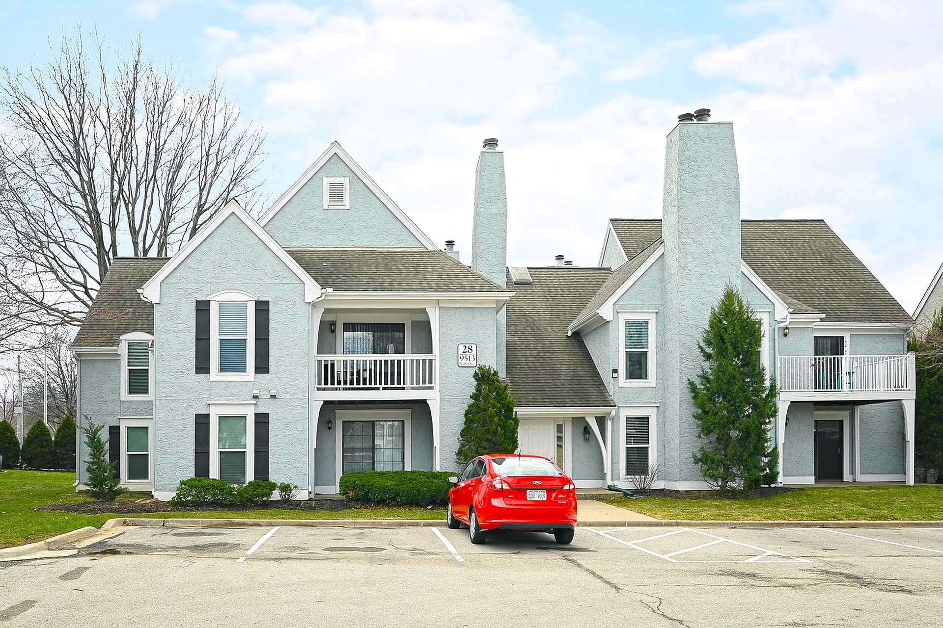 Charming duplex with modern gray exterior, double chimneys, and inviting balconies, perfect for urban living.