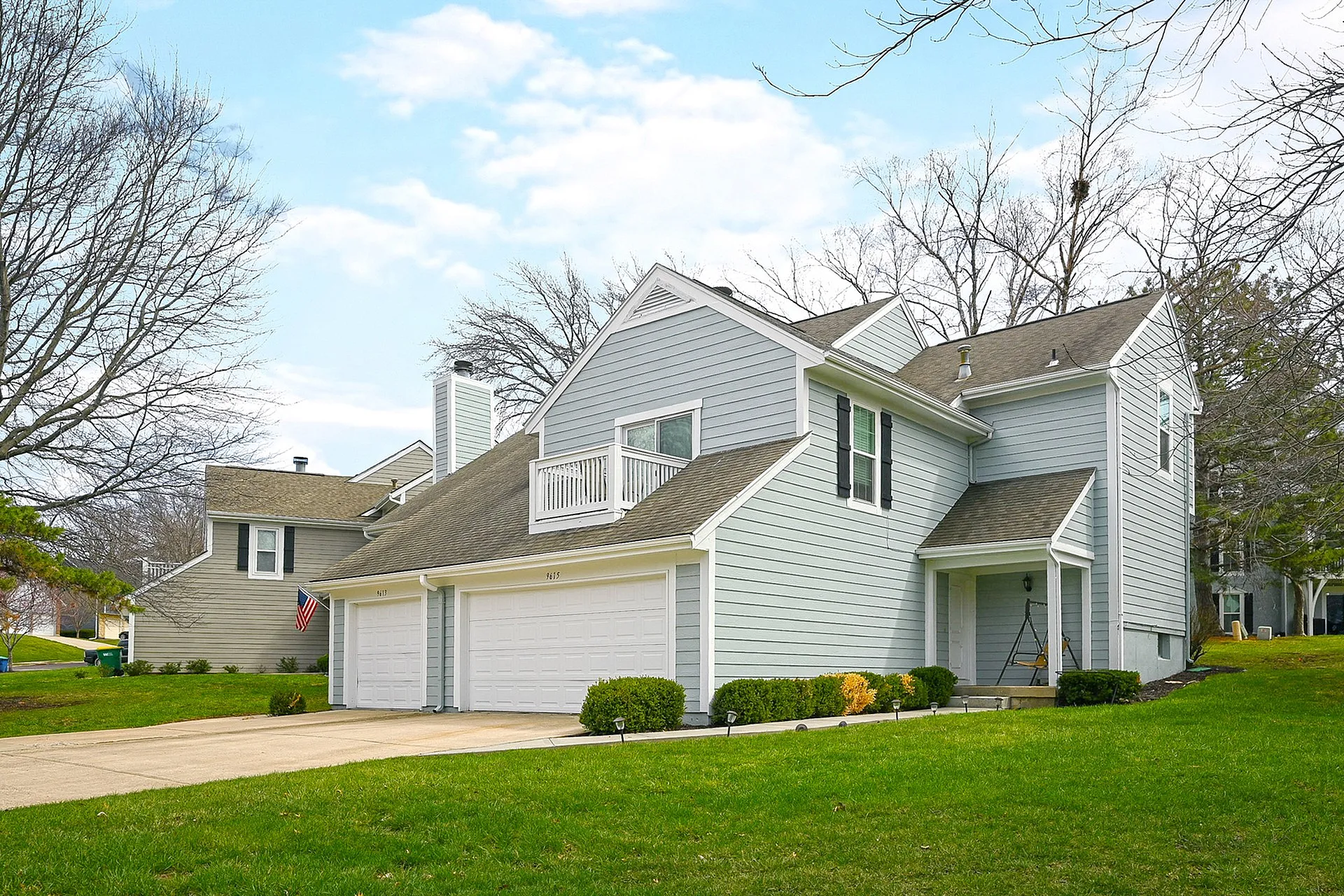 Charming suburban home with a spacious front yard, double garage, and modern architectural design under a clear blue sky.